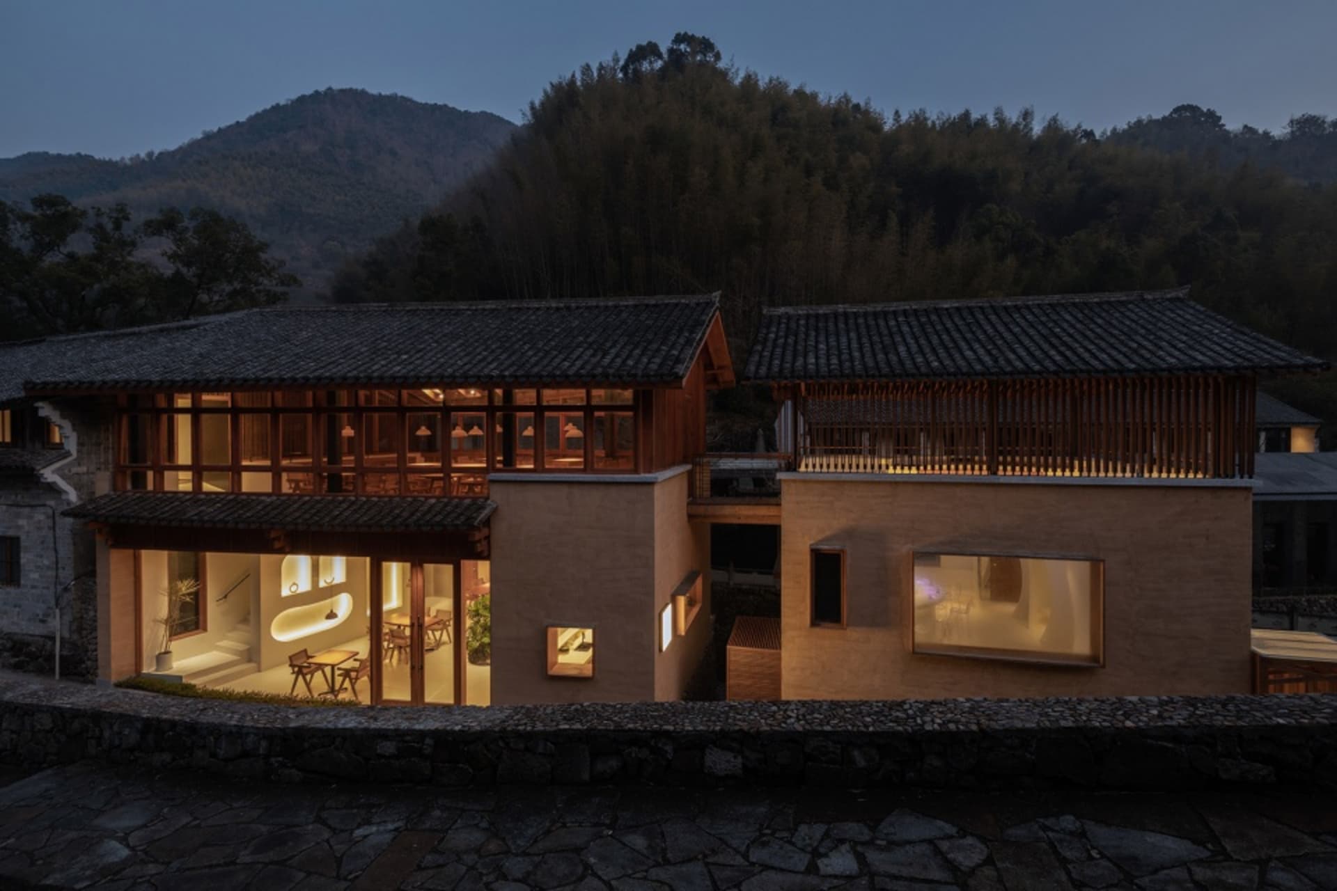 大型木構石頂亞洲風住宅，包含多個房間，其中有設有椅子與盆栽的餐廳區域