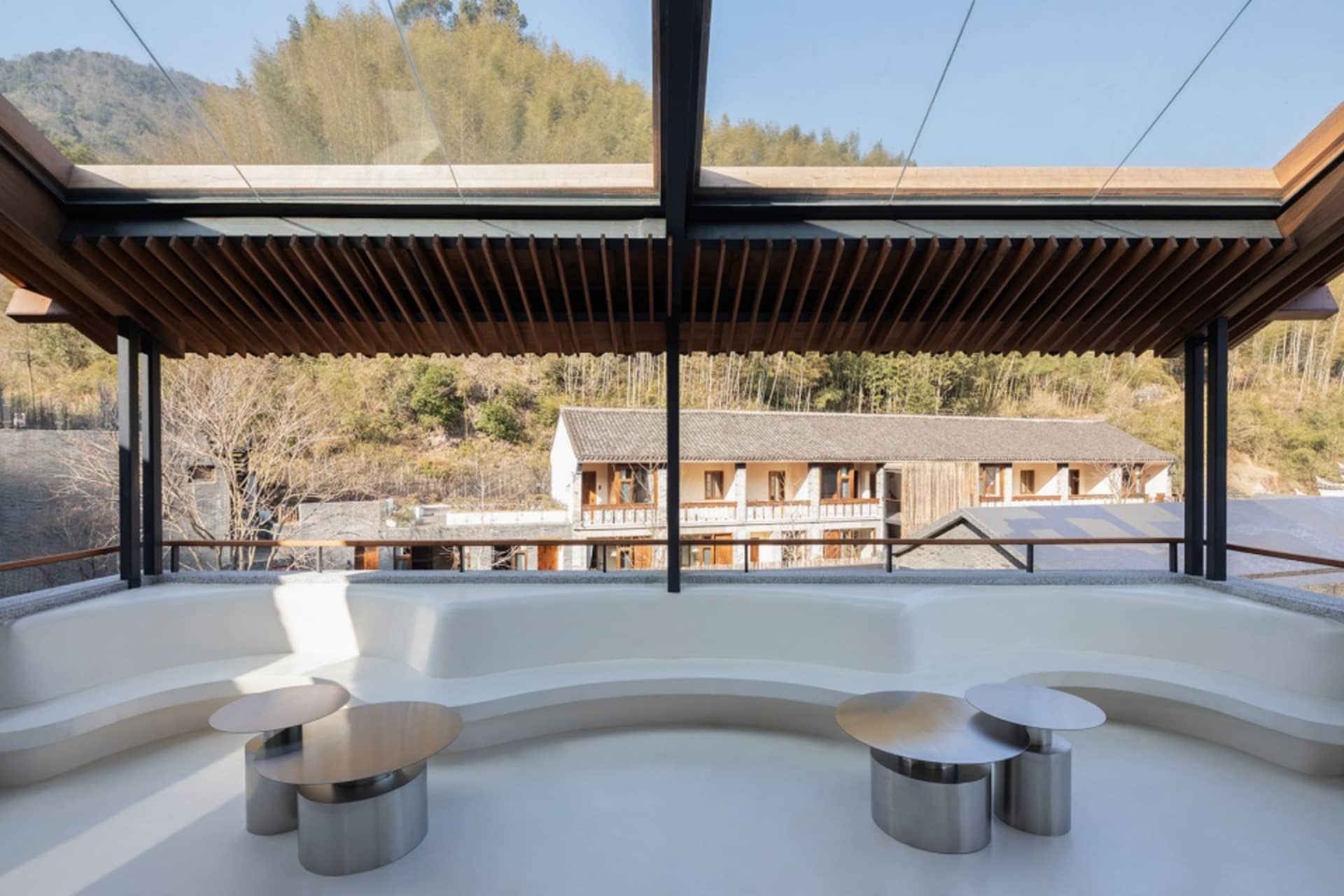 A modern open space with a glass ceiling, round tables, and a bright and airy ambiance