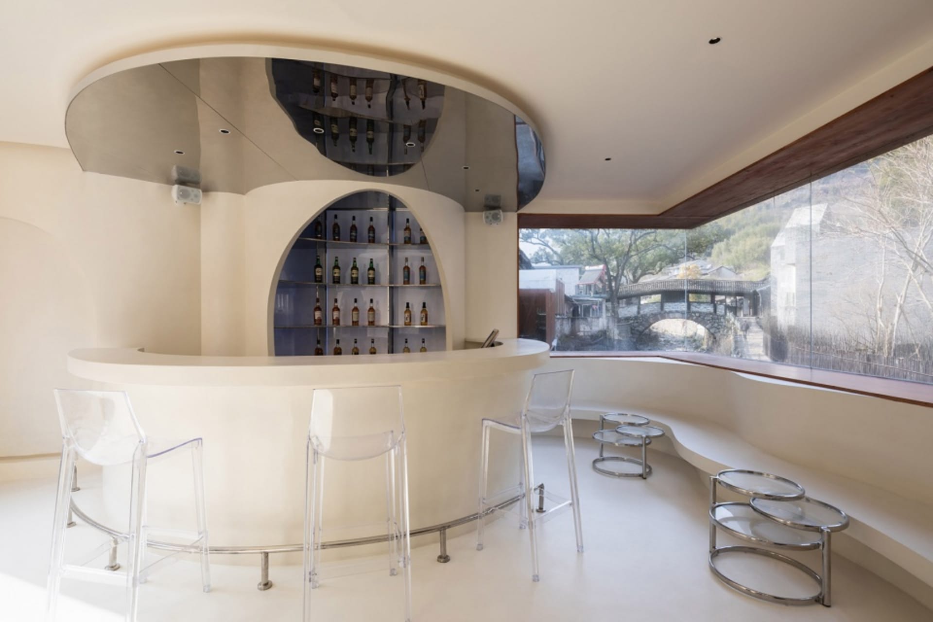 Modern bar area with a circular wine rack and seating for patrons, featuring a stylish and functional design