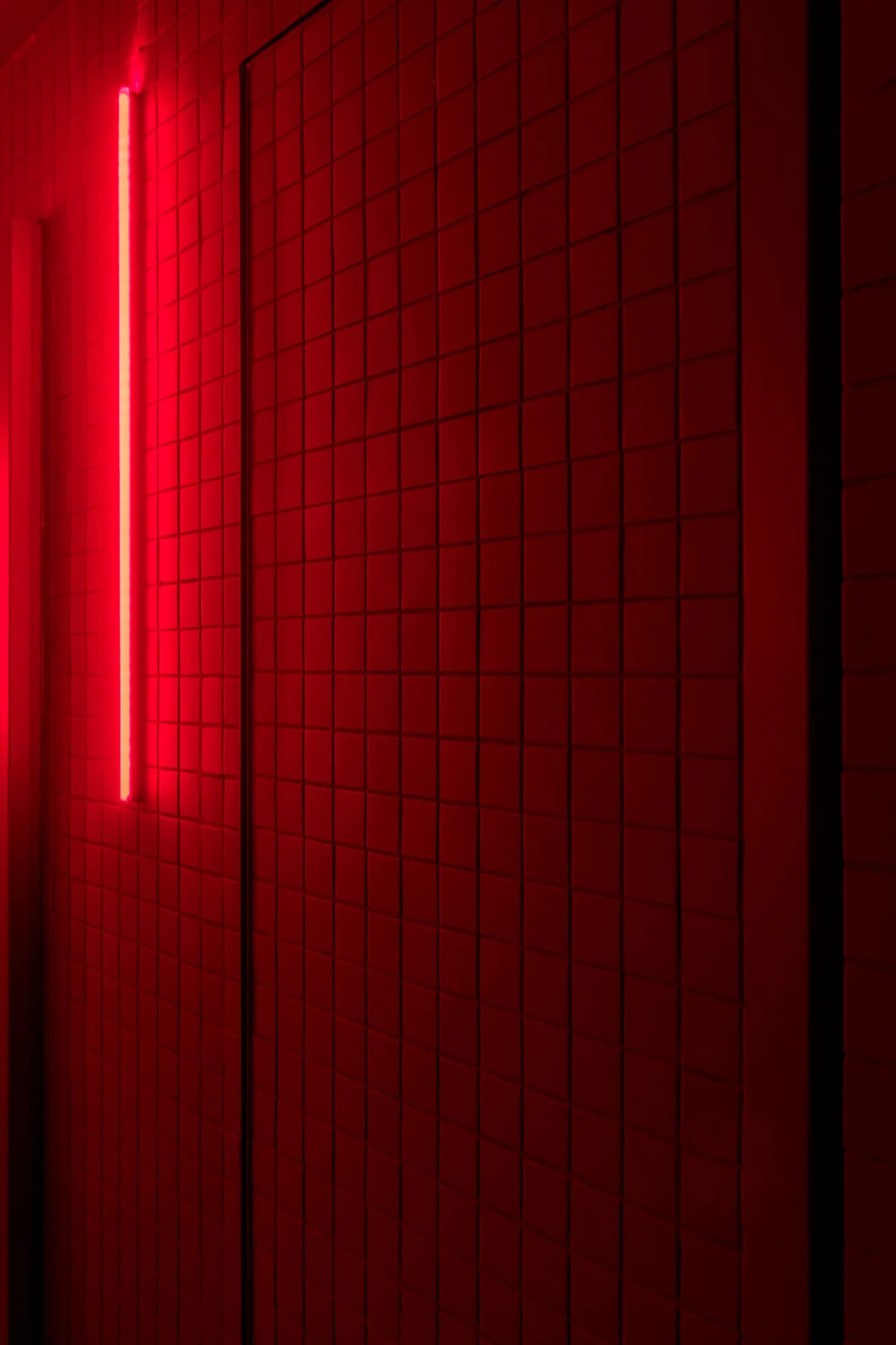 A bathroom with a red brick wall illuminated by a red light, creating a warm and inviting atmosphere