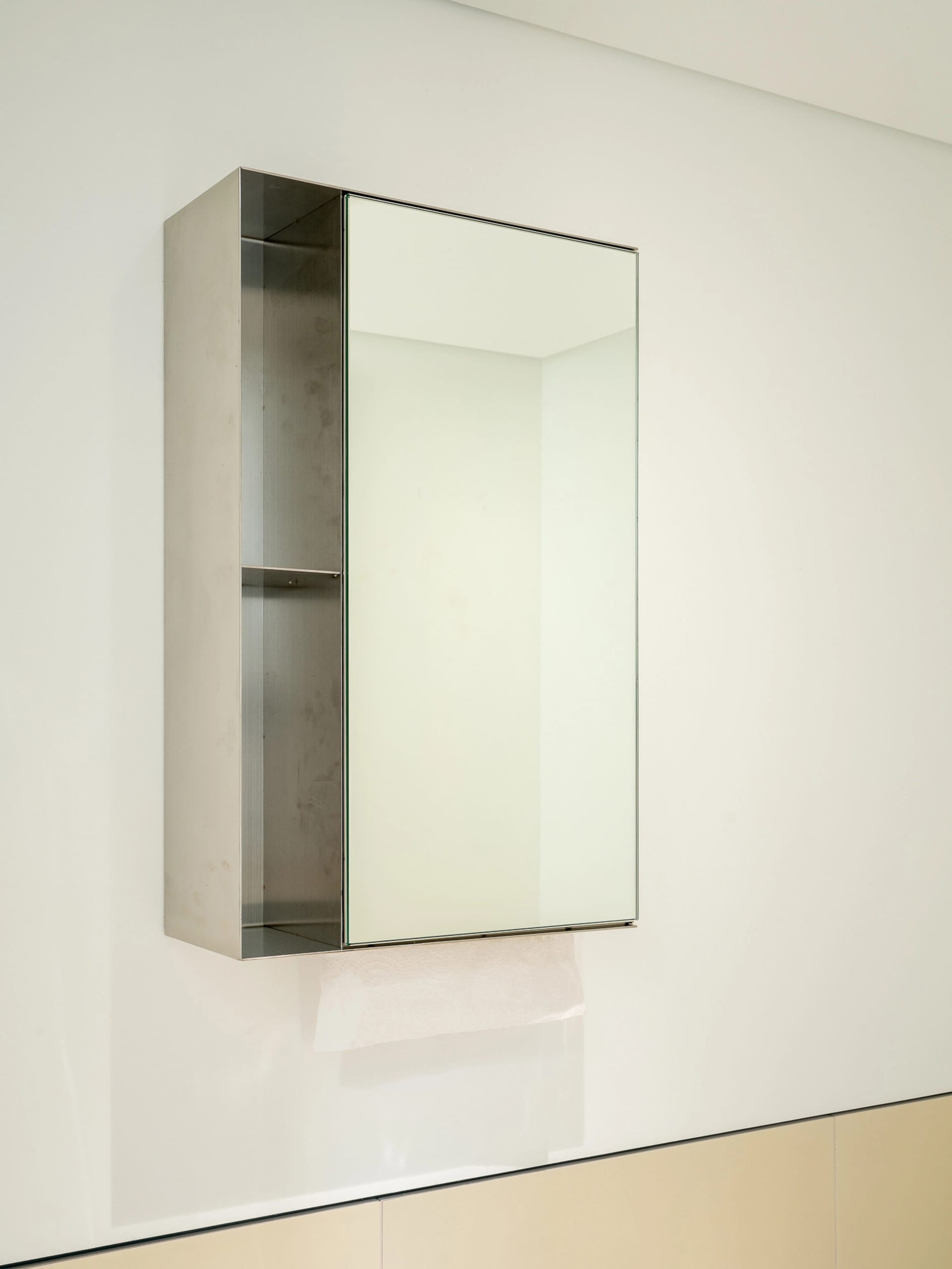 Clean and modern bathroom with a wall-mounted mirror and empty sink area