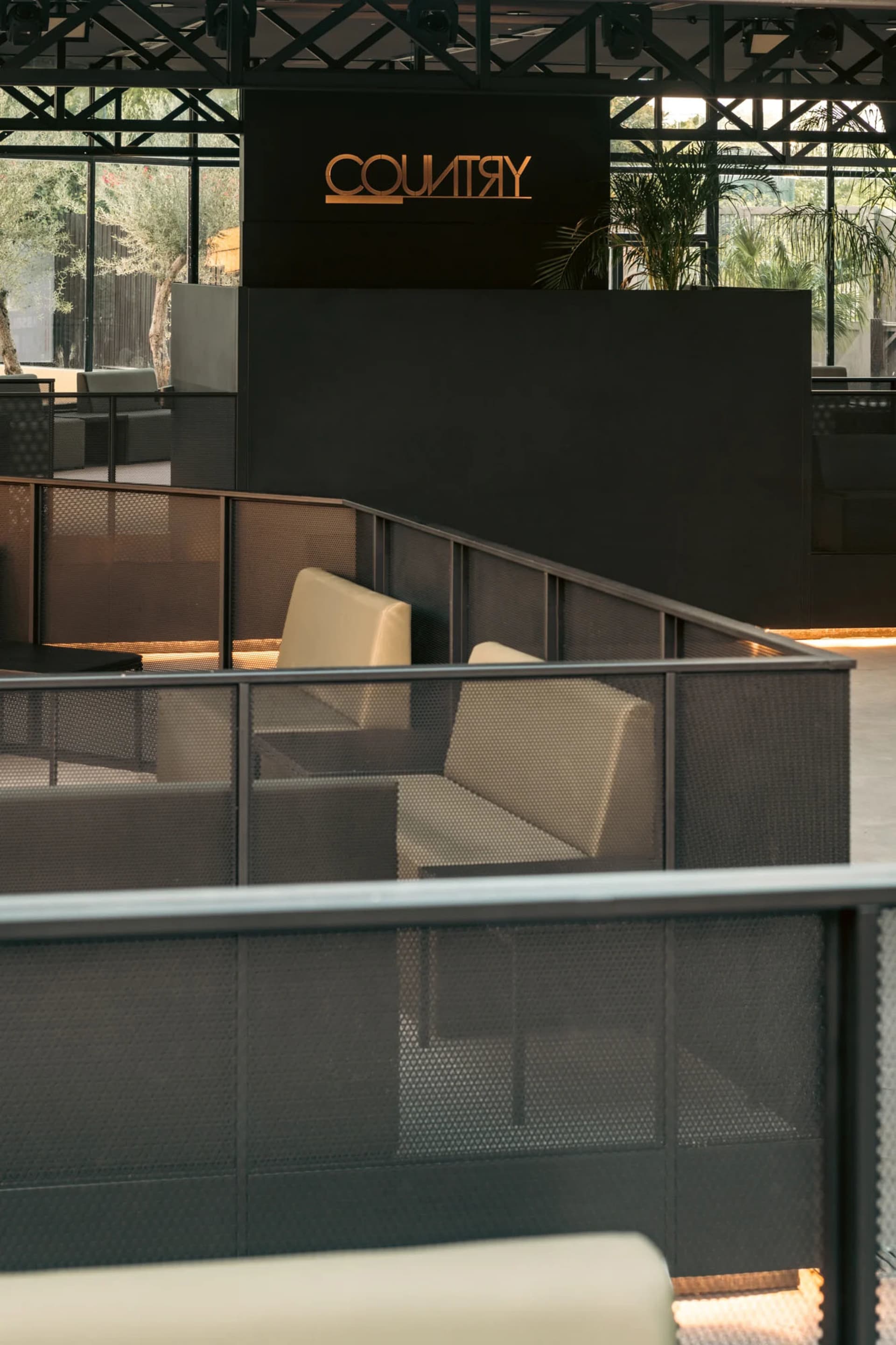 Comfortable indoor space with multiple couches and chairs arranged around a central point, creating a warm and inviting atmosphere for socializing and relaxation