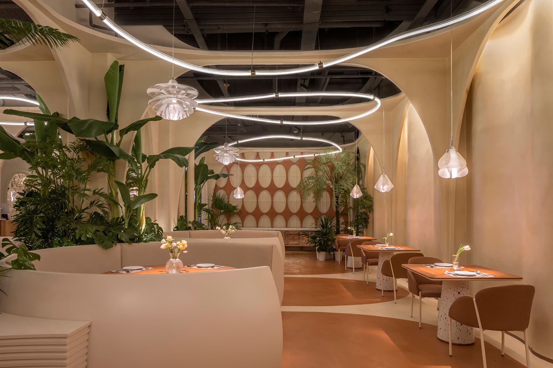 Modern restaurant interior with white walls, brown floors, and dining tables and chairs