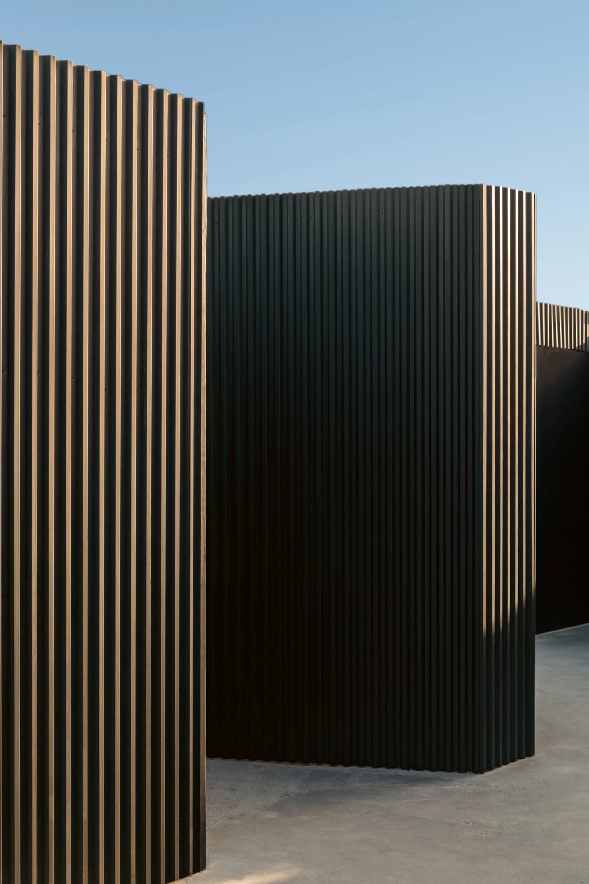 Three black metal panels arranged in a row on a wall, creating a sleek and modern visual effect