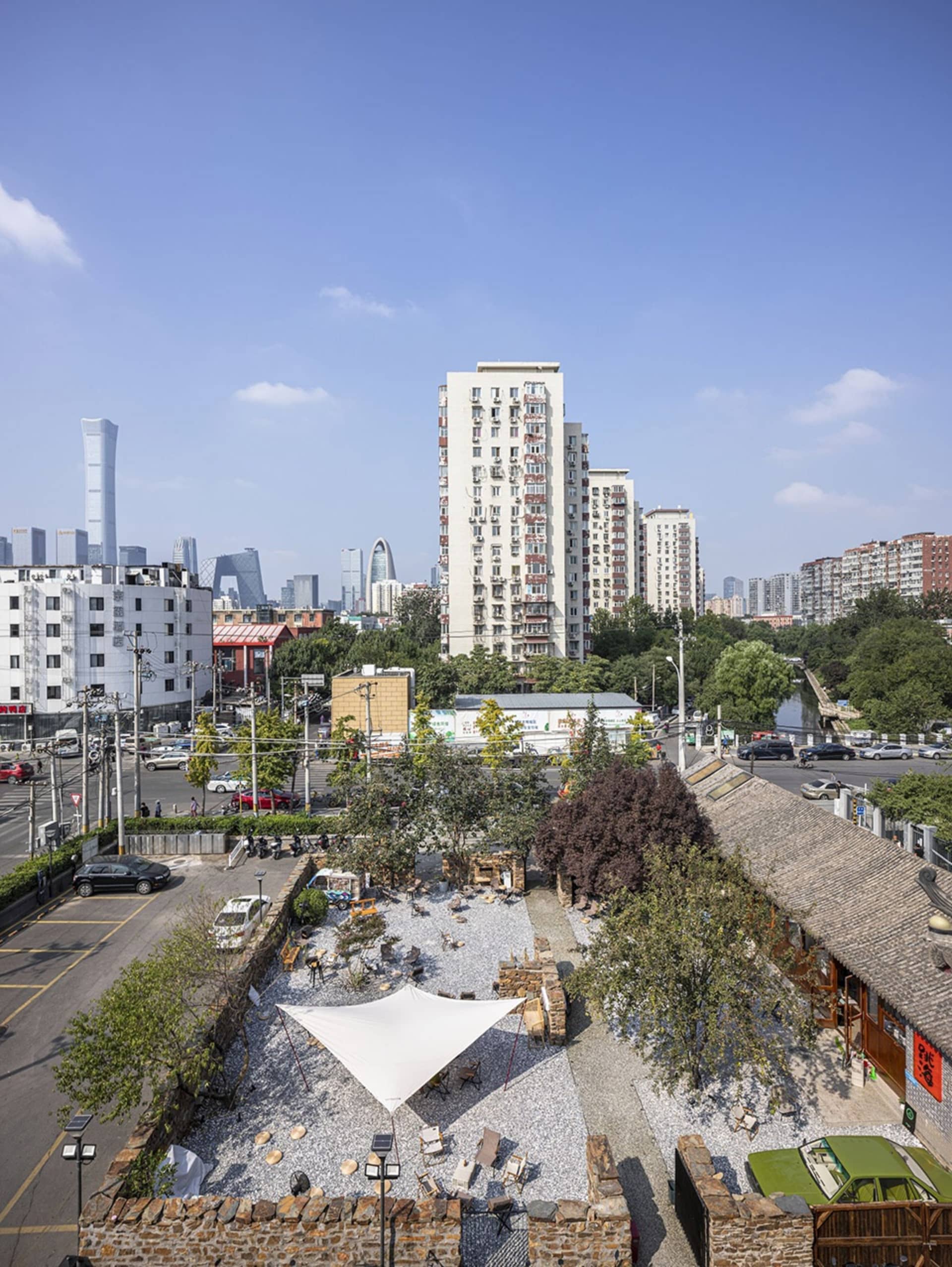 A bustling city scene with modern concrete and glass buildings, cars, and people going about their daily activities