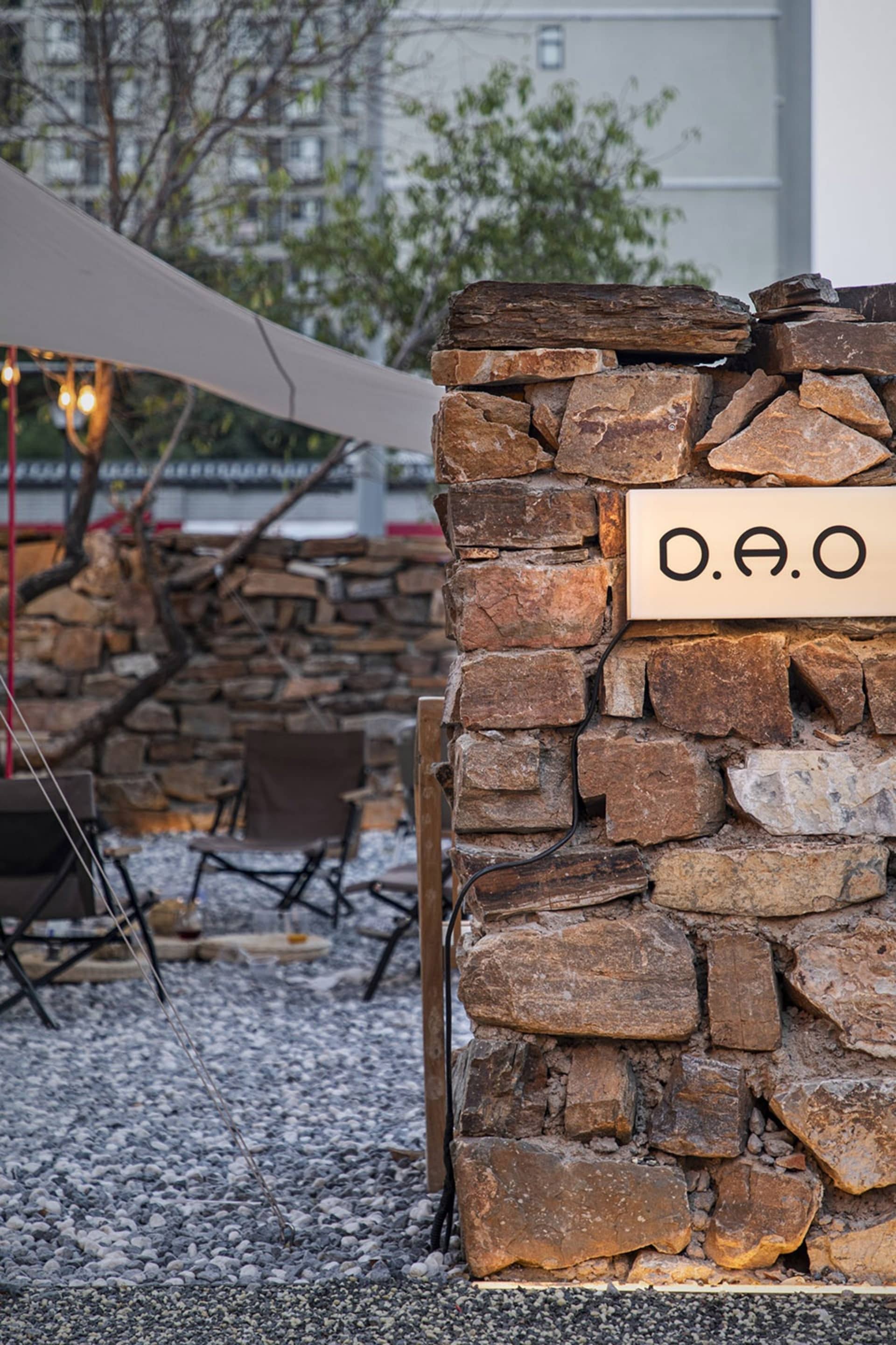 A casual outdoor seating area with several chairs and dining tables, surrounded by a relaxed atmosphere