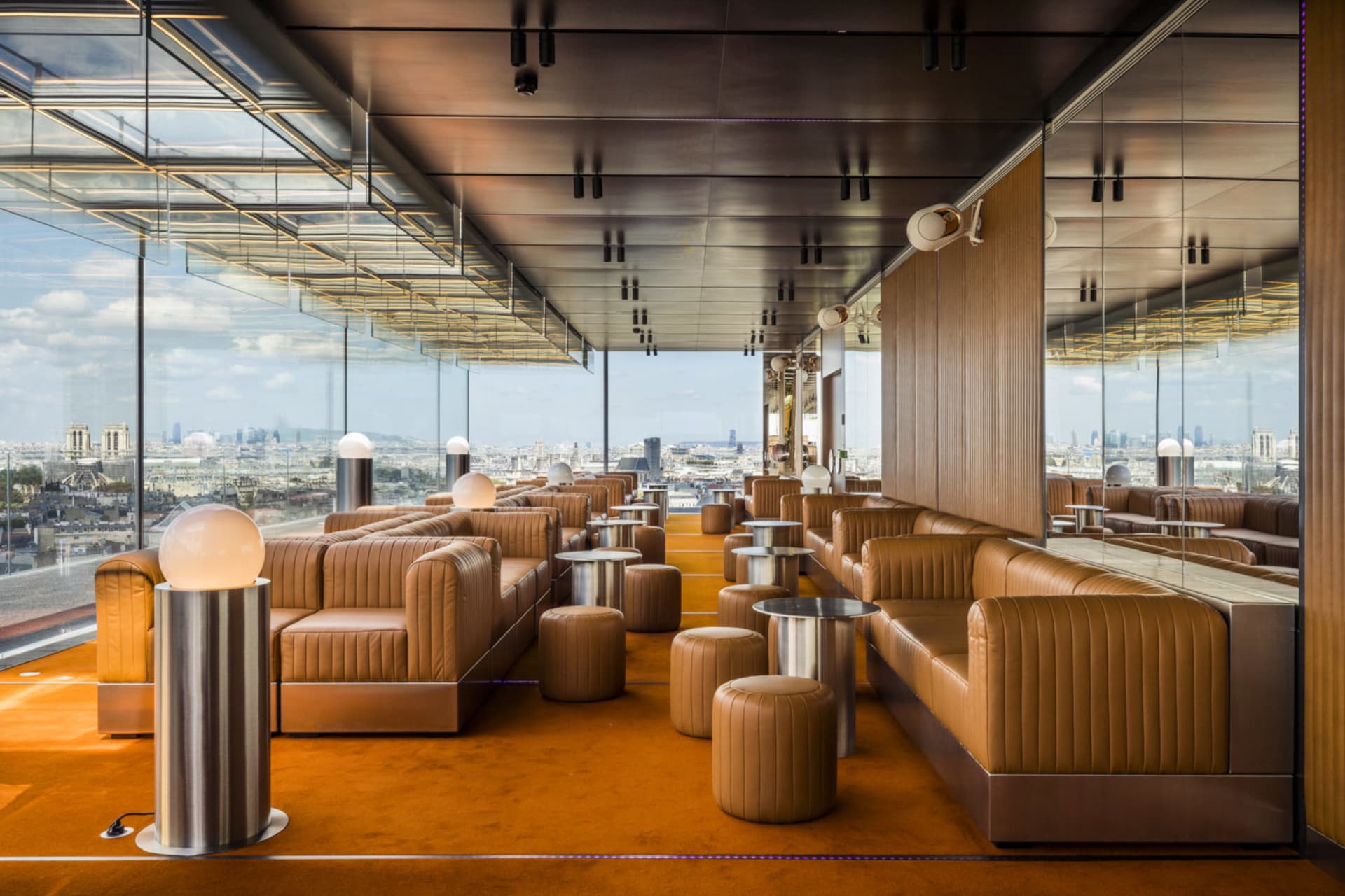 Warm and inviting restaurant interior with orange carpeting, couches, chairs, and dining tables