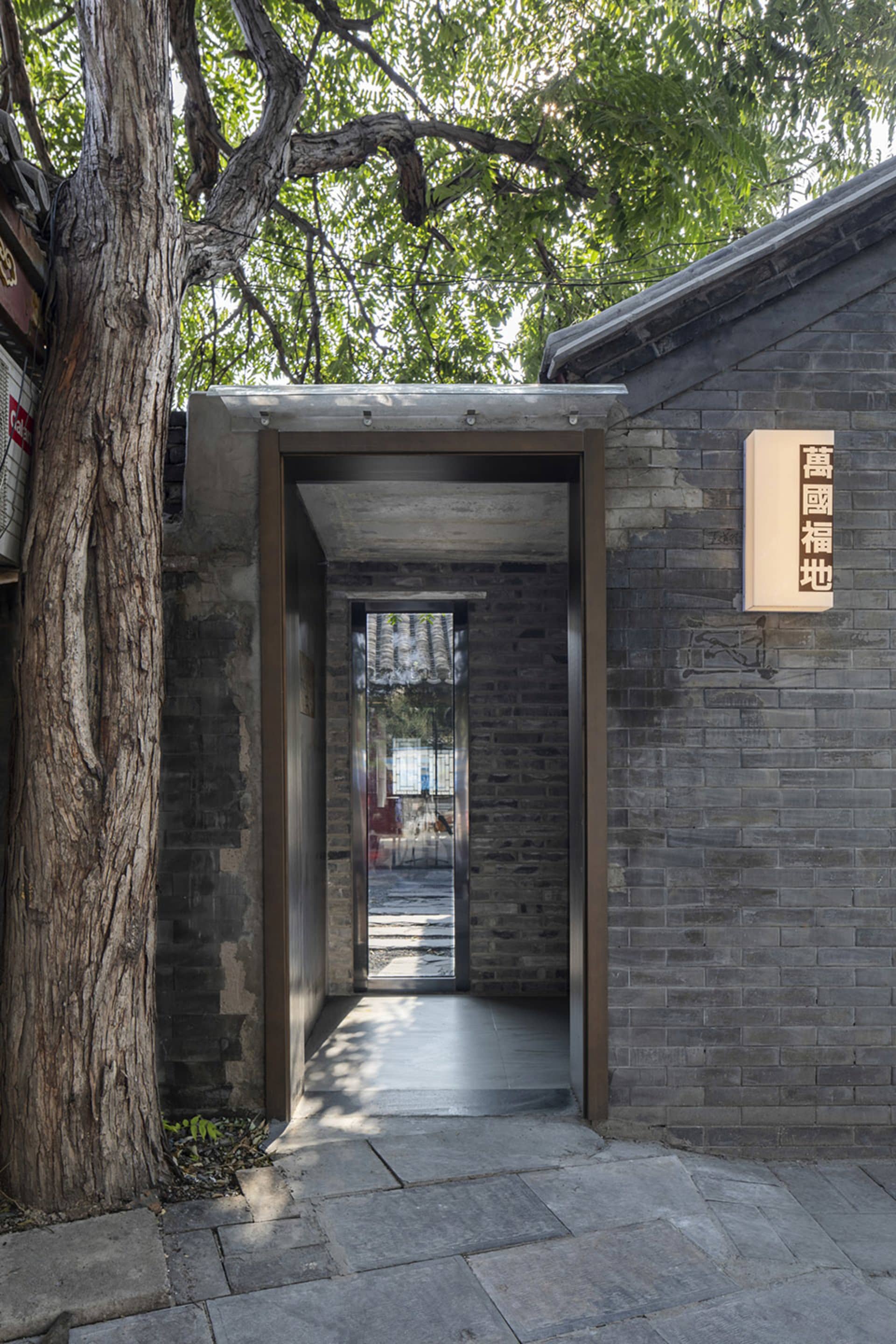 A small room with a stone wall, brick floor, and two windows, creating a calm and serene atmosphere