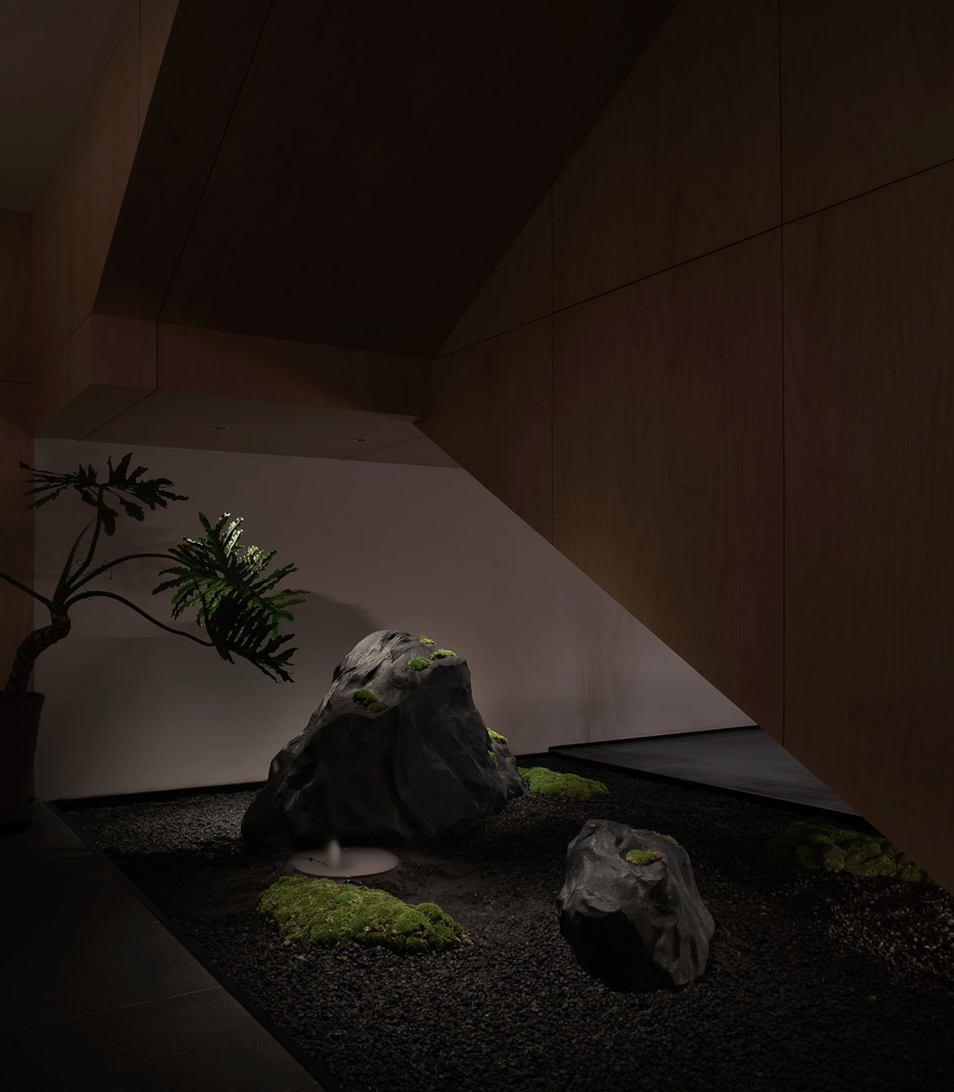 溫馨舒適的客廳空間，設有岩石庭園、盆栽與座椅，營造自然氛圍與柔和燈光