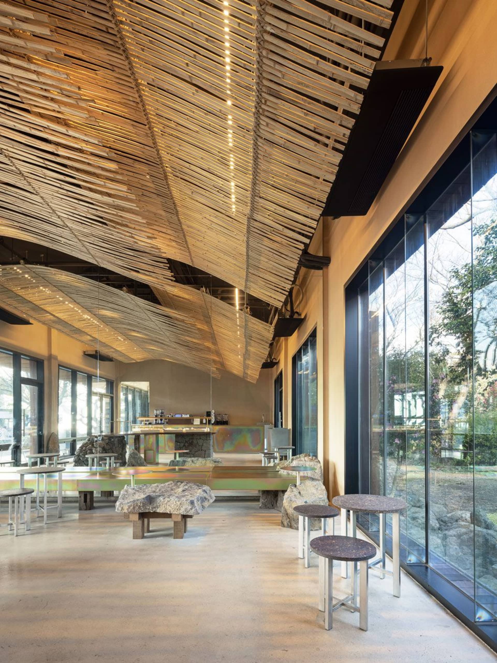 Modern restaurant interior with a bar, dining area, and ample seating options, featuring bottles and a welcoming atmosphere