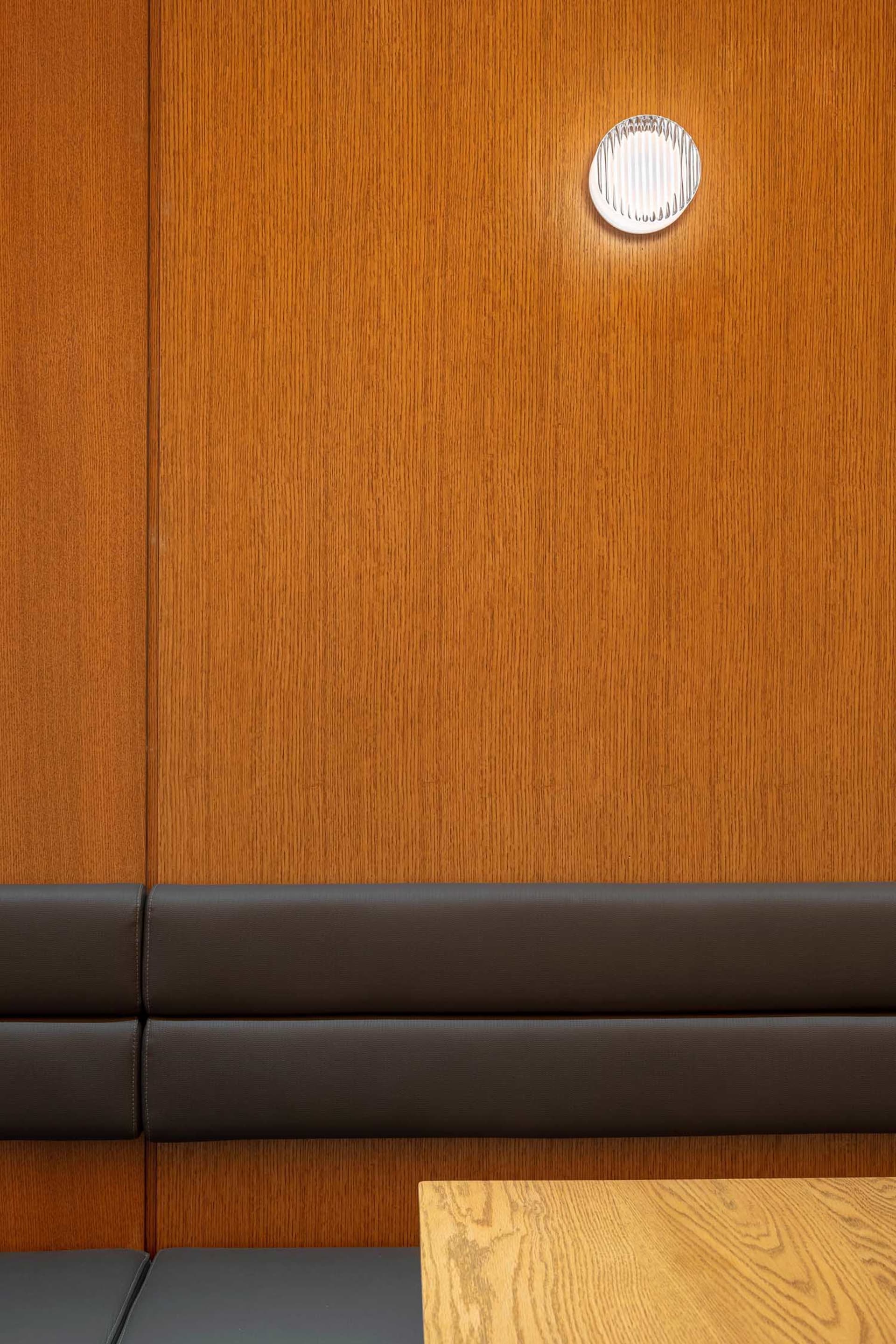 A warm and cozy interior design space with wooden walls, two brown leather couches, and a comfortable atmosphere