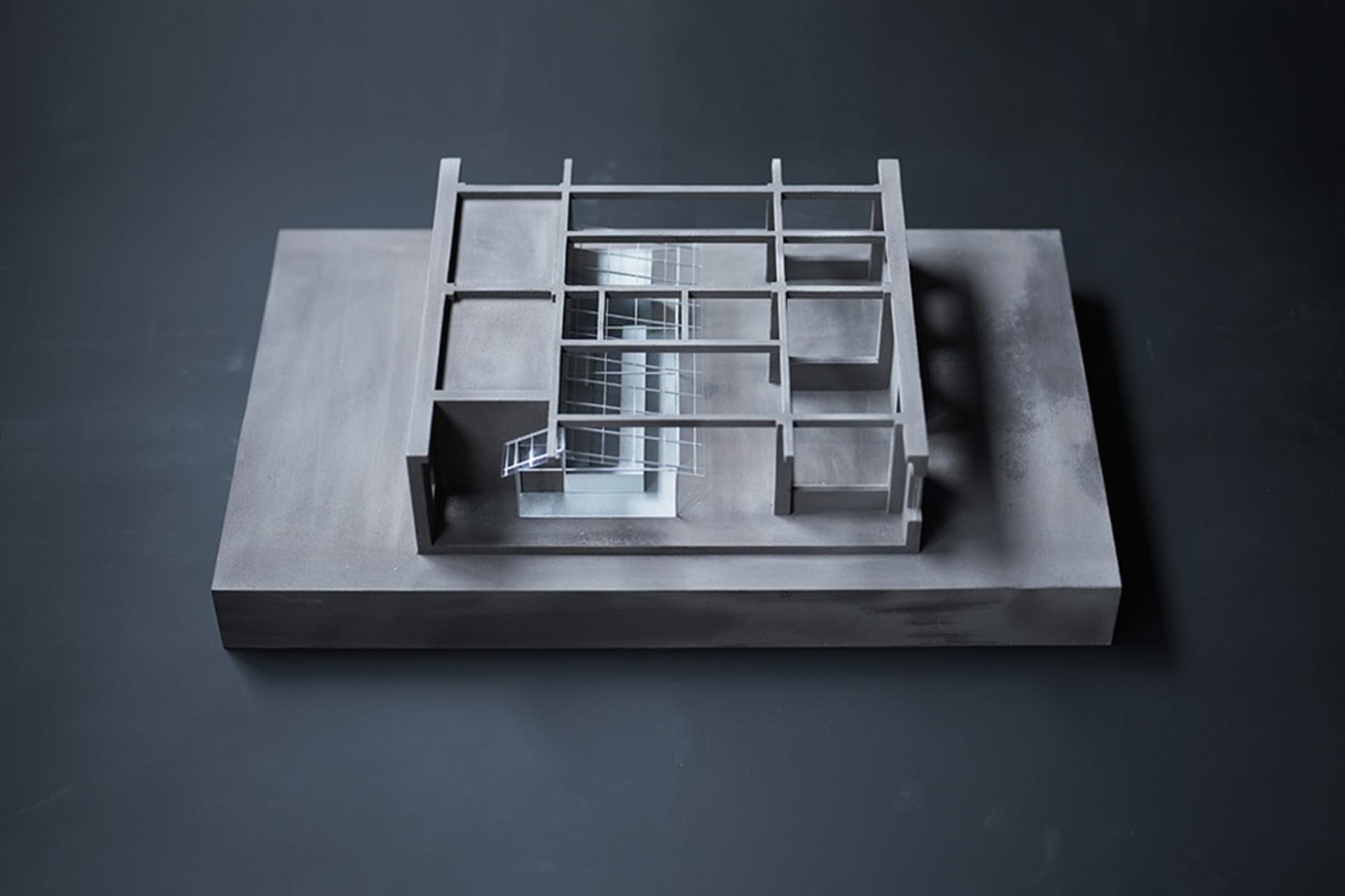 Black and white architectural model of a modern house with clean lines, minimalistic features, and visible concrete and metal materials