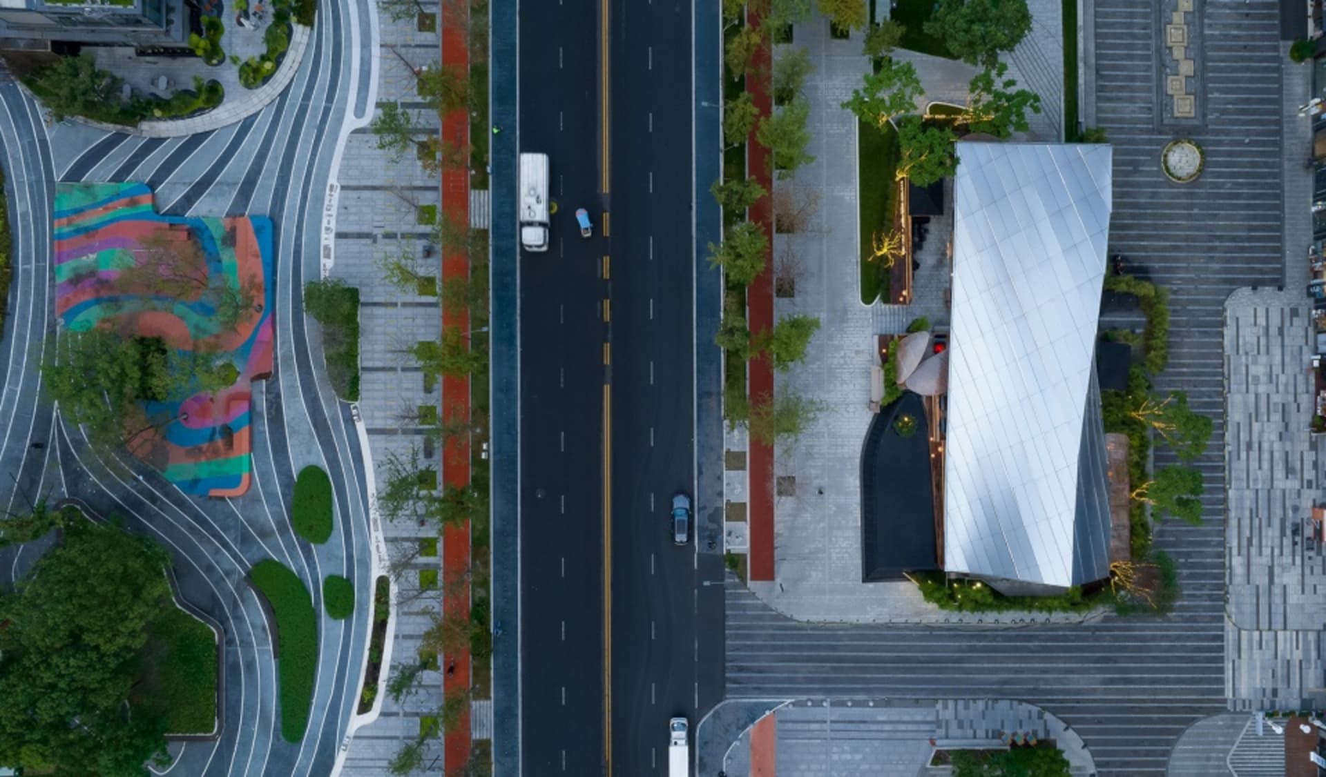 Aerial view of a bustling city street intersection with multiple vehicles and a mix of traffic flow
