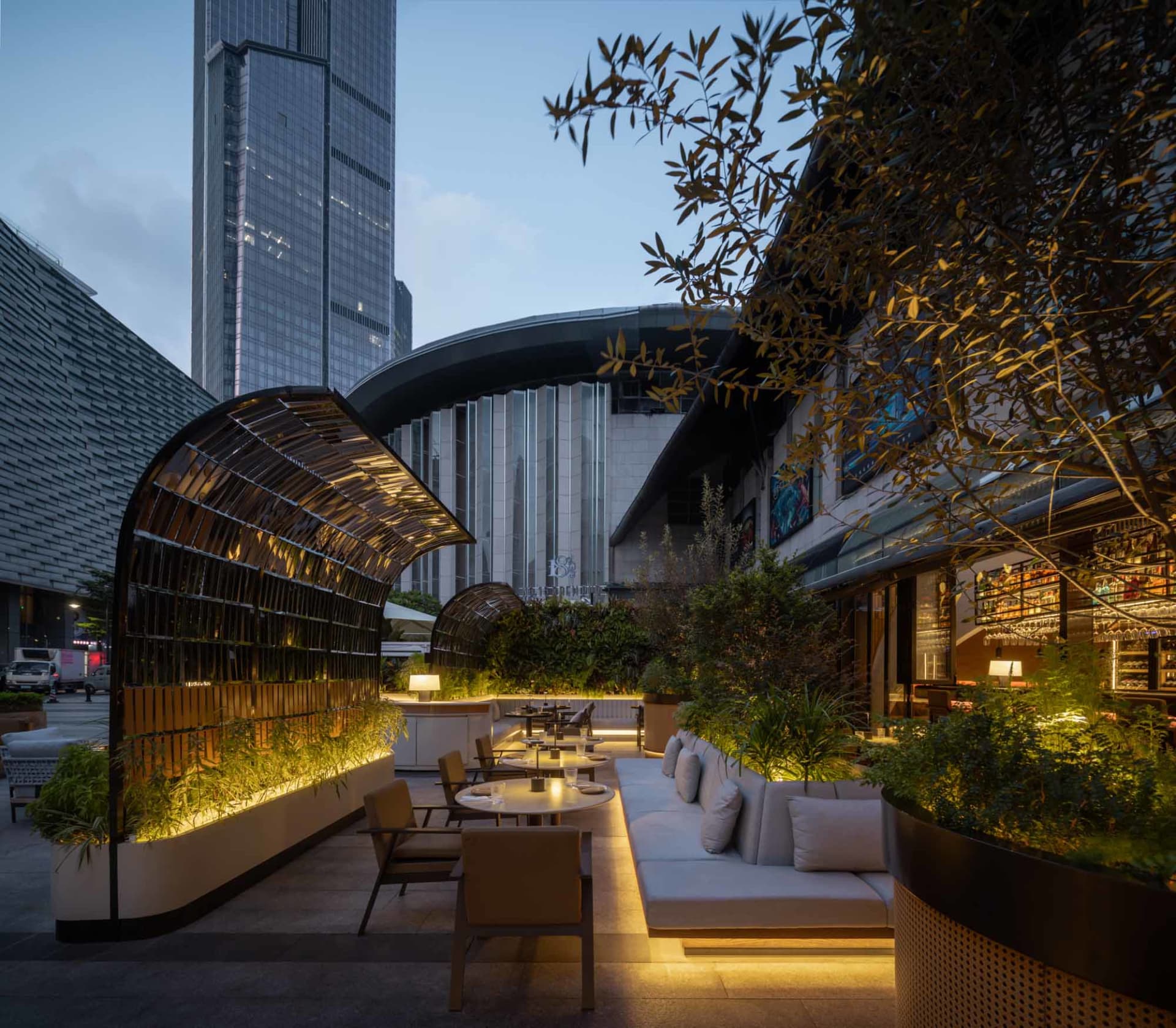 夜晚現代餐廳露台，設有玻璃結構、舒適座椅與溫馨氛圍