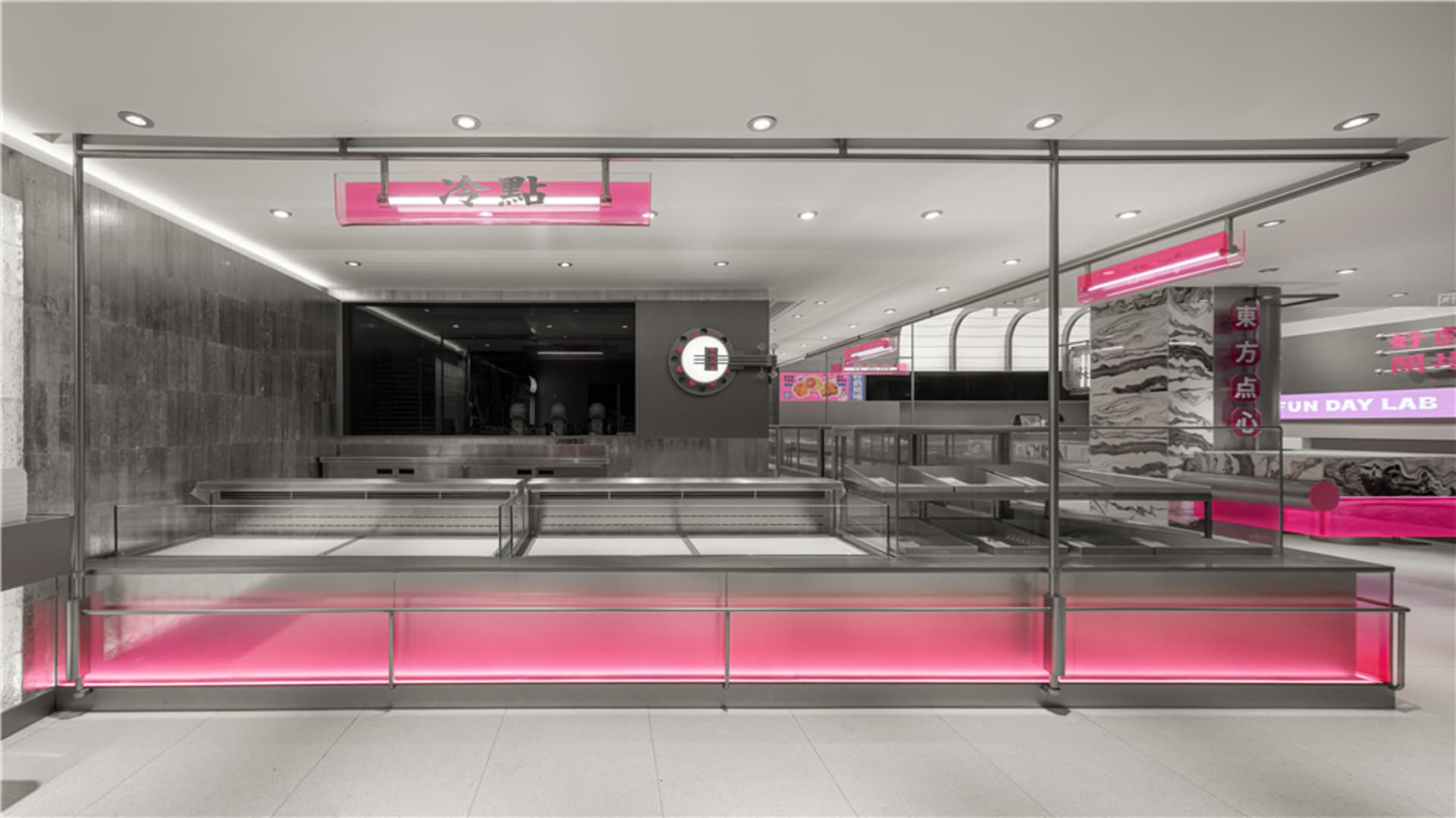 A modern restaurant with pink walls, a counter, and people, creating a warm atmosphere