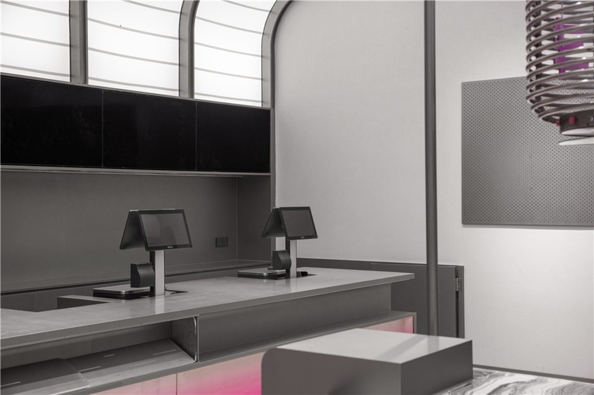 An empty restaurant counter with two cash registers and a metal surface, giving a modern and sleek appearance