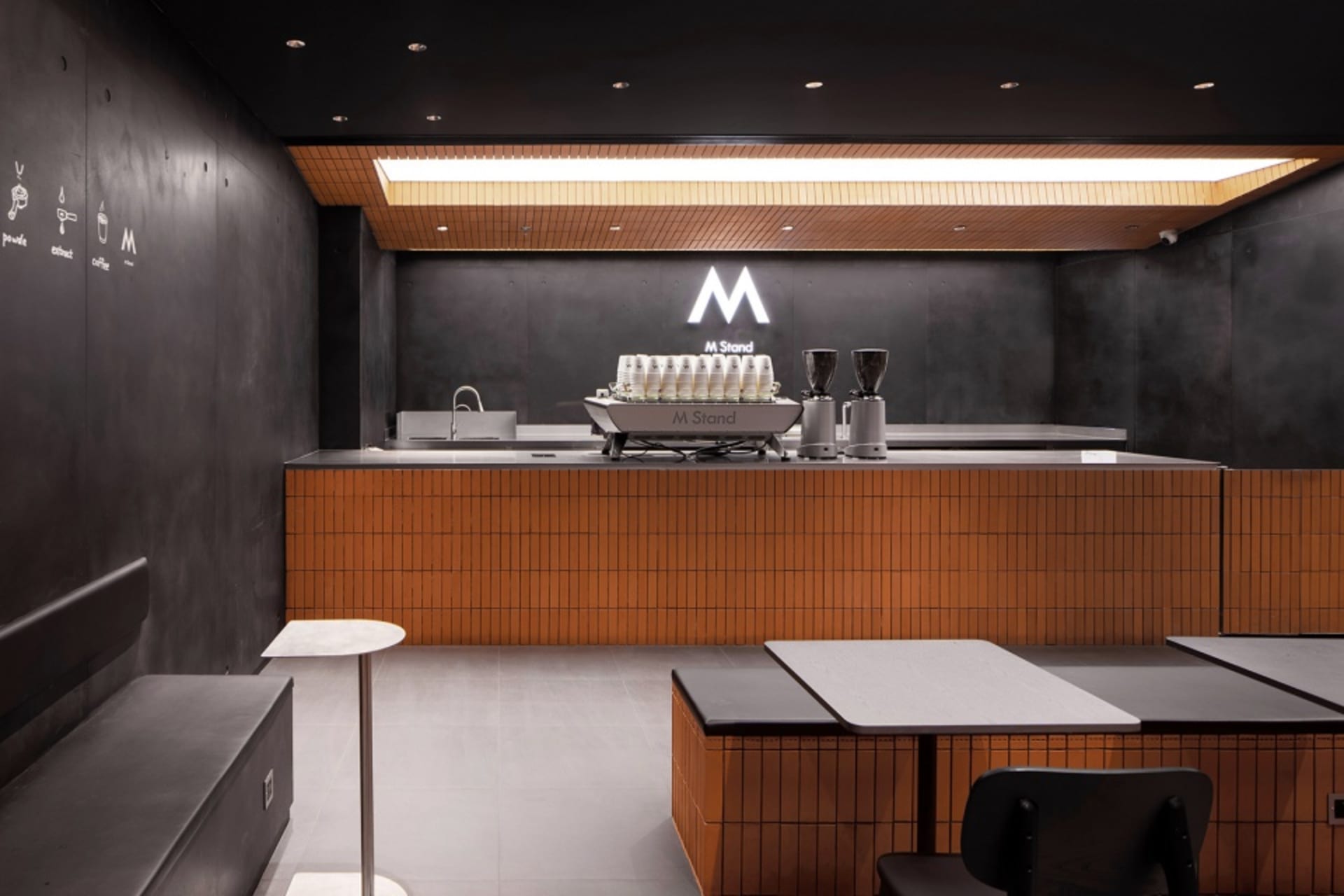 Industrial kitchen with a counter featuring two coffee machines and cups, clean and well-organized atmosphere