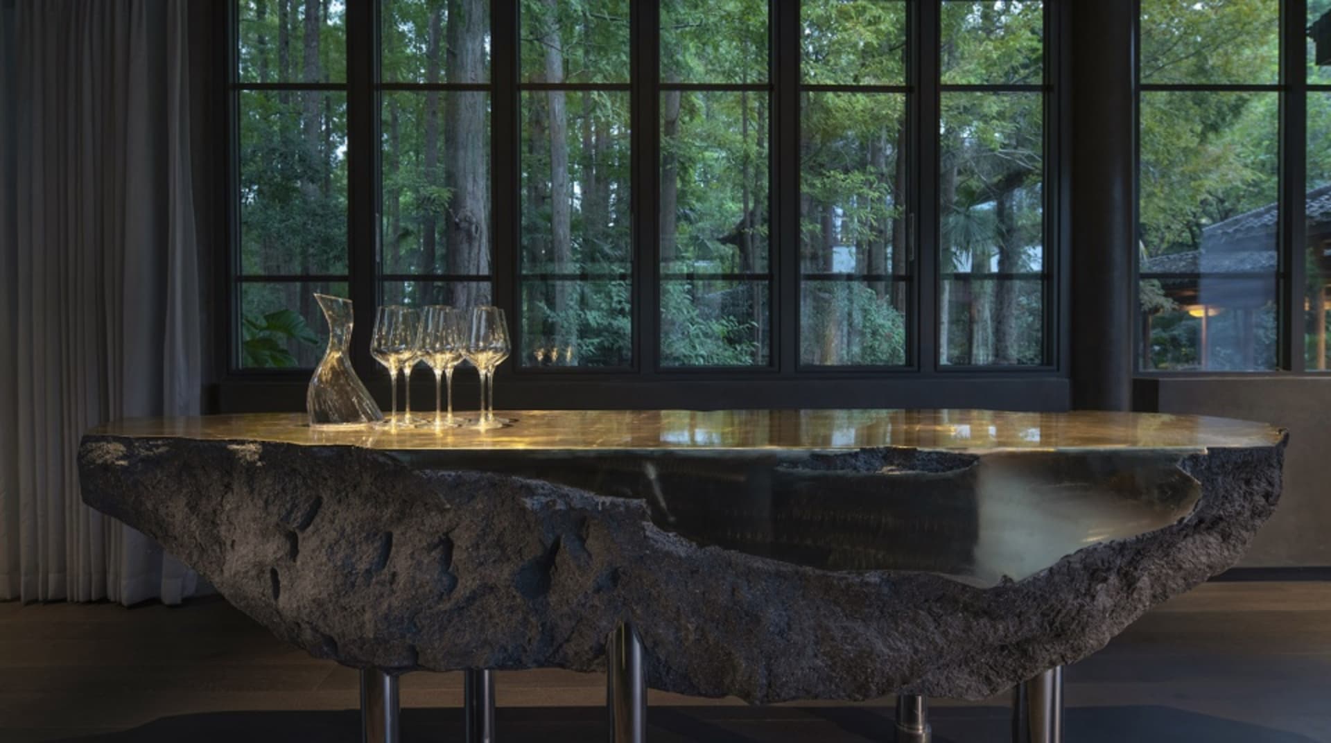 A sophisticated dining area with a glass table, wine glasses, and inviting ambiance