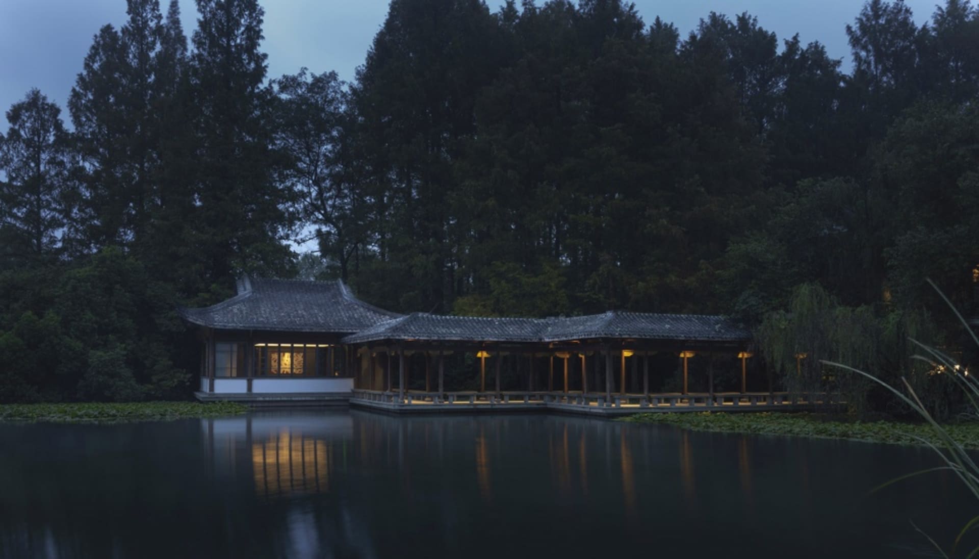 亞洲風建築鄰近水域，具獨特屋頂設計，自然光透過窗戶灑入，營造寧靜氛圍
