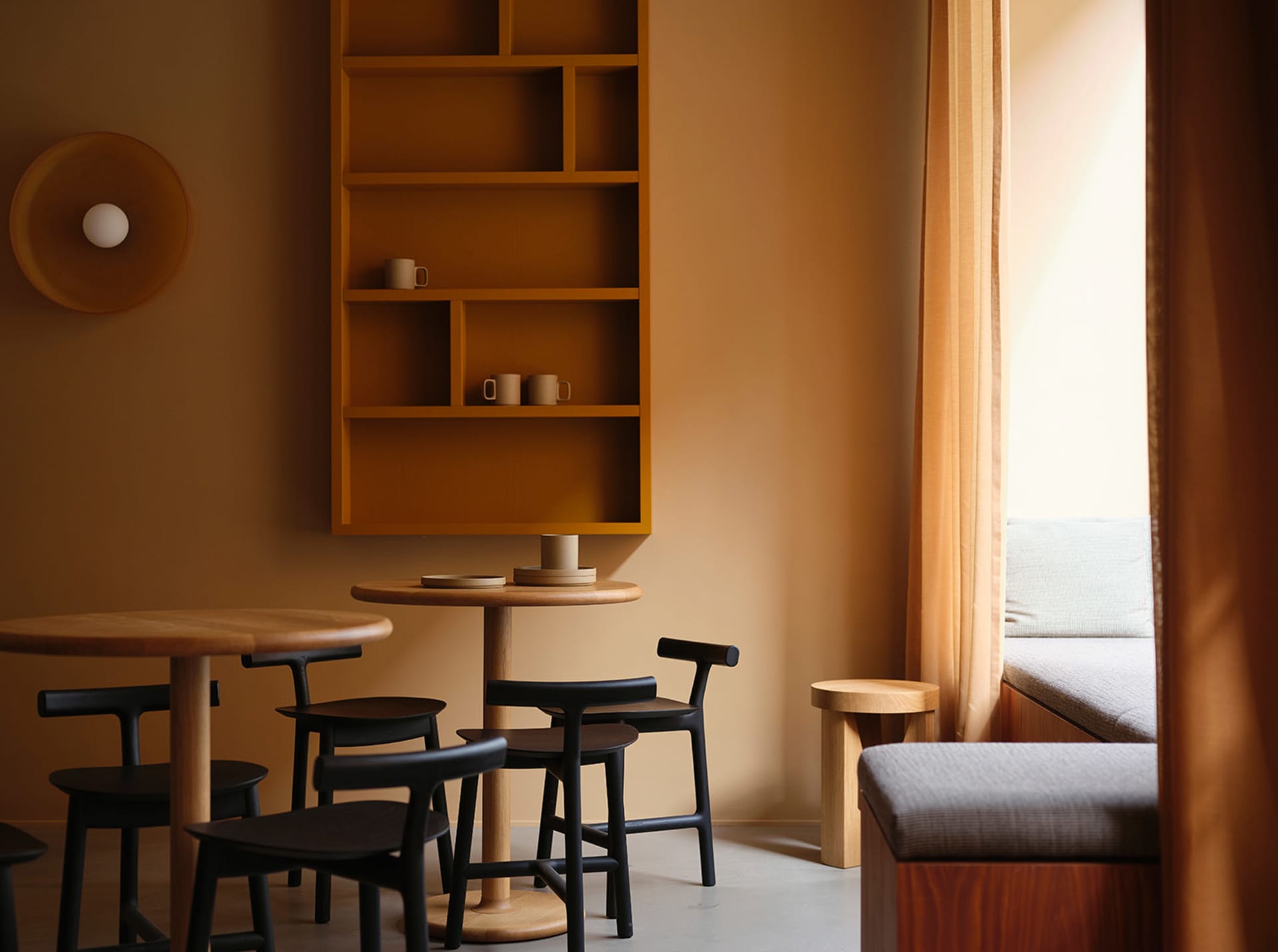 A modern living space with a dining table, chairs, and a couch, featuring wooden floors and walls, creating a warm and inviting atmosphere