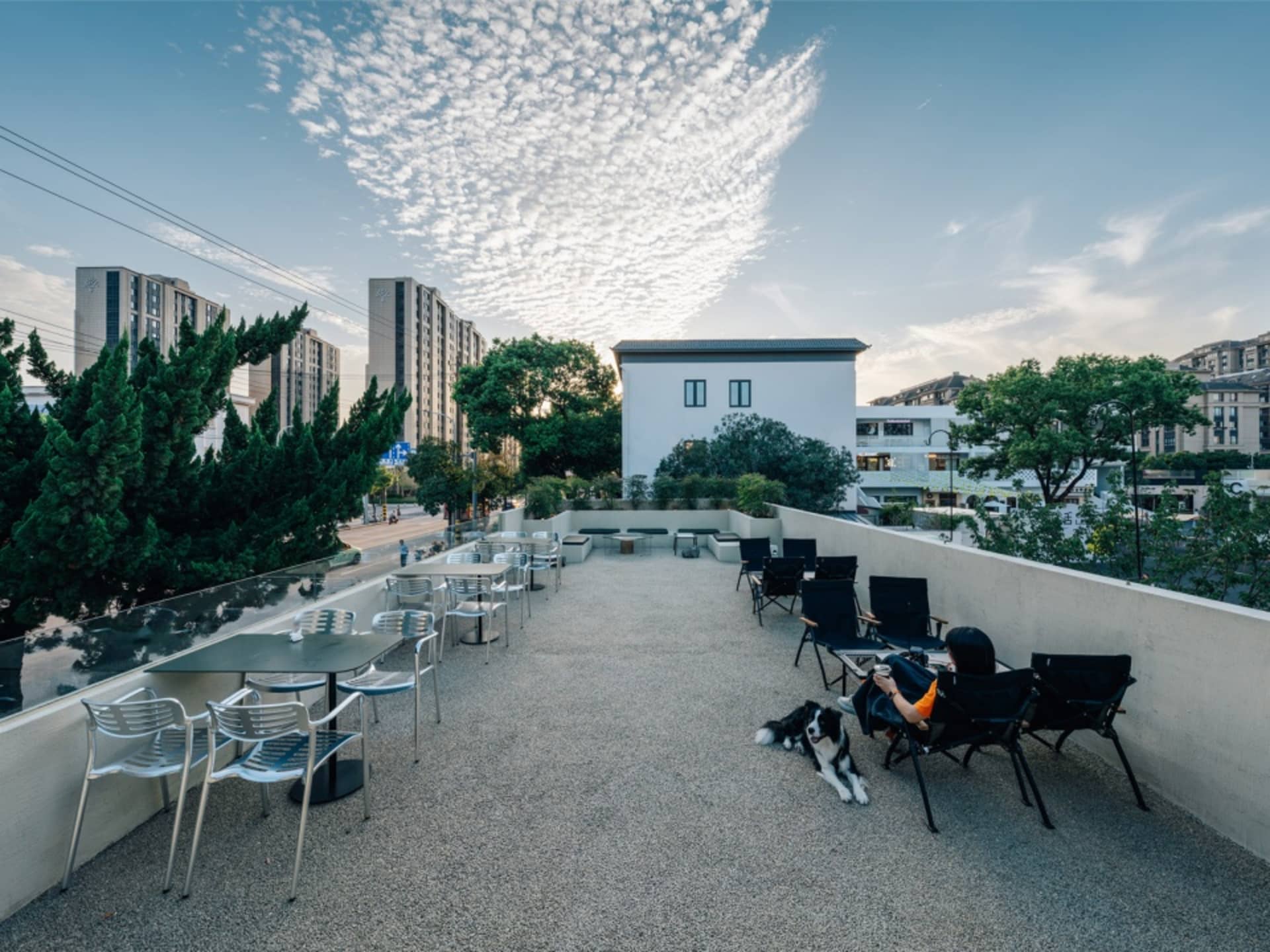 A sunny outdoor patio with wicker chairs and tables, surrounded by sunlight and a relaxed atmosphere