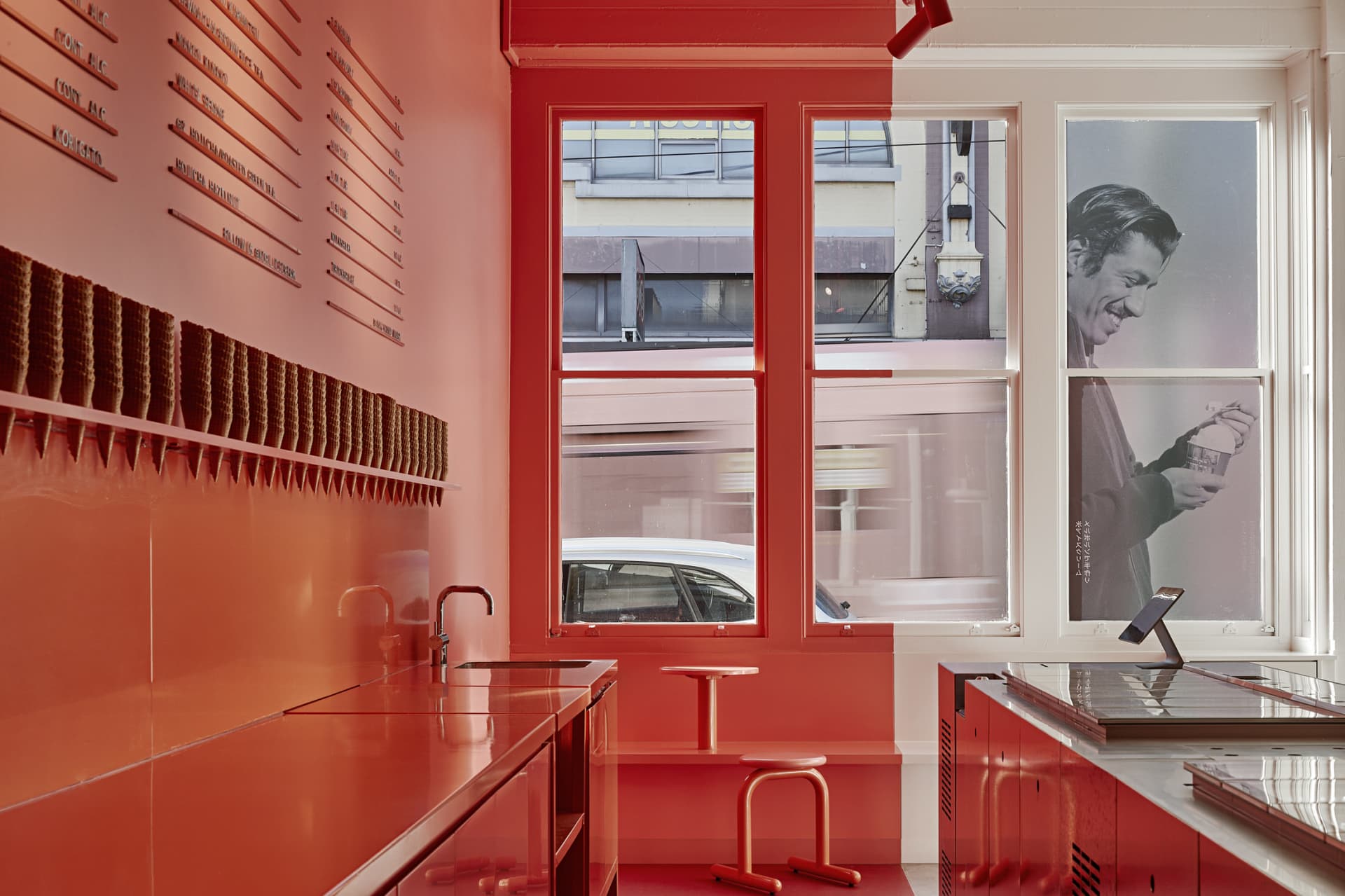 Warm kitchen with red walls, natural light, and a chair for dining or additional seating