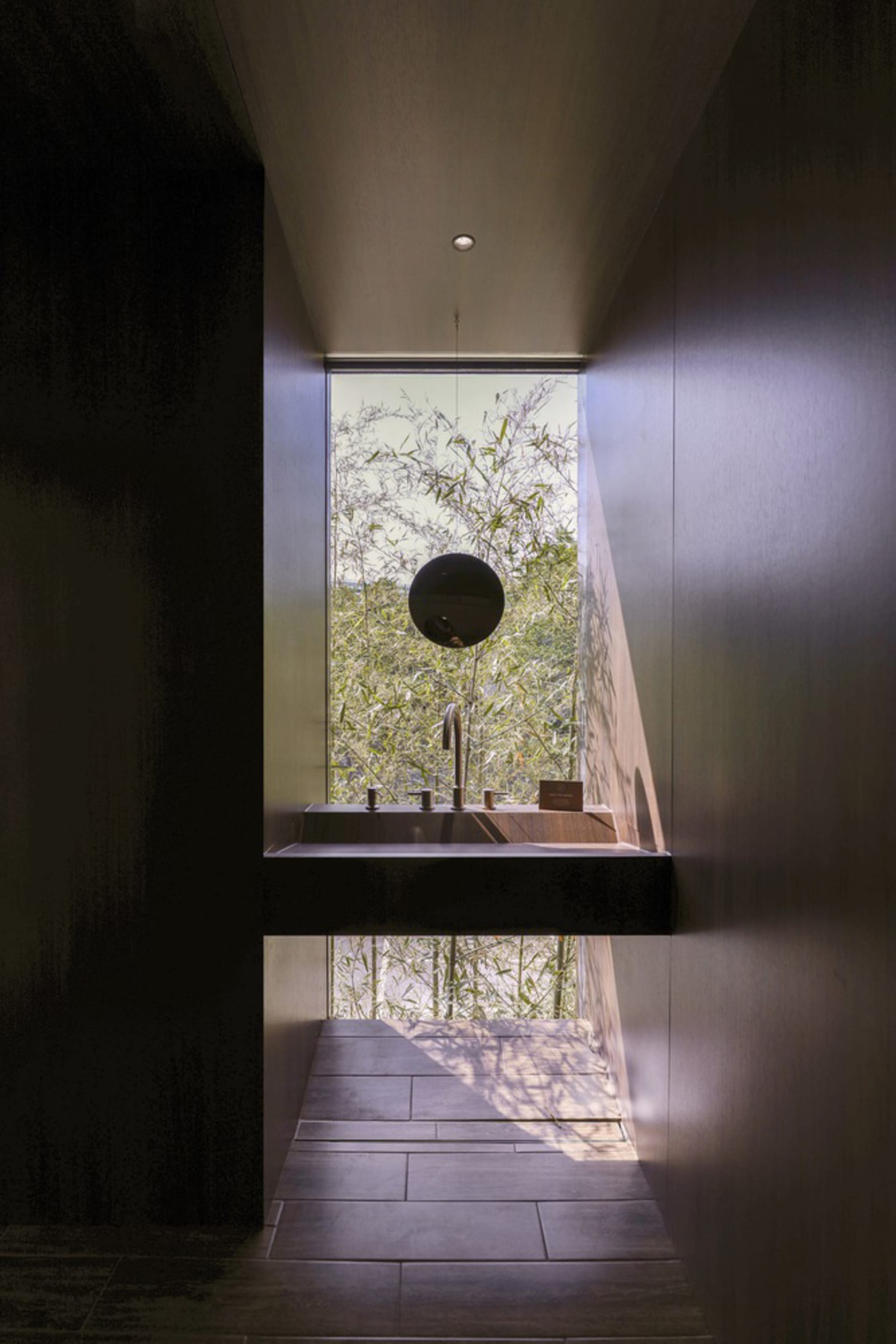 A well-lit bathroom with two sinks, one with a mirror above, under a window, with a clean and organized atmosphere