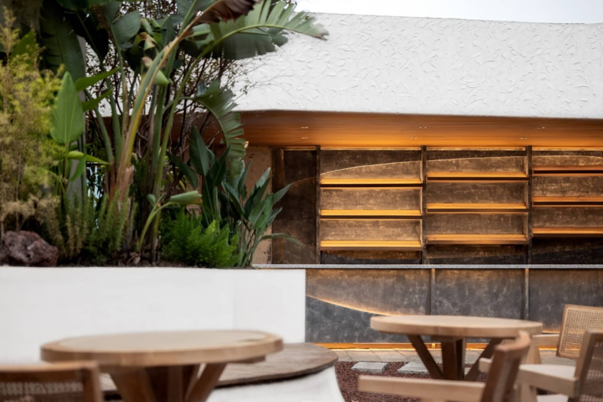 Casual dining area with a wooden counter, metal chairs, and two dining tables