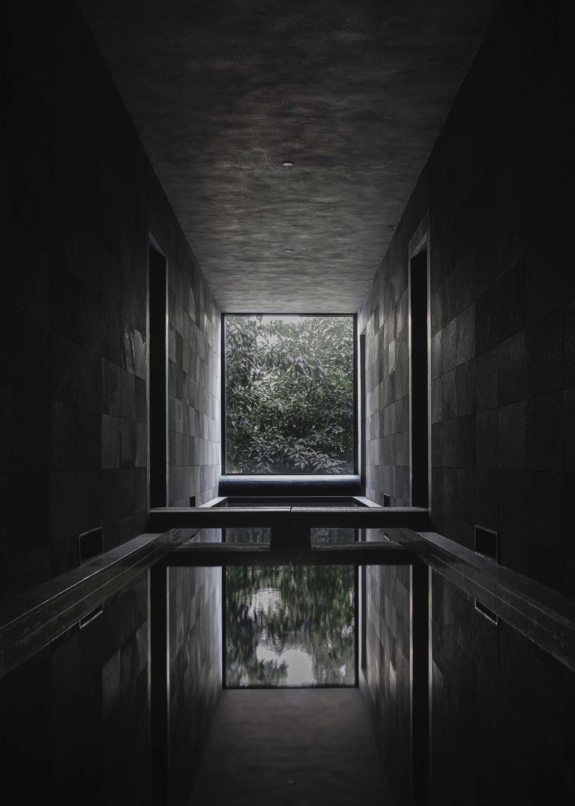 Indoor pool area with stone walls, two benches, and a luxurious atmosphere