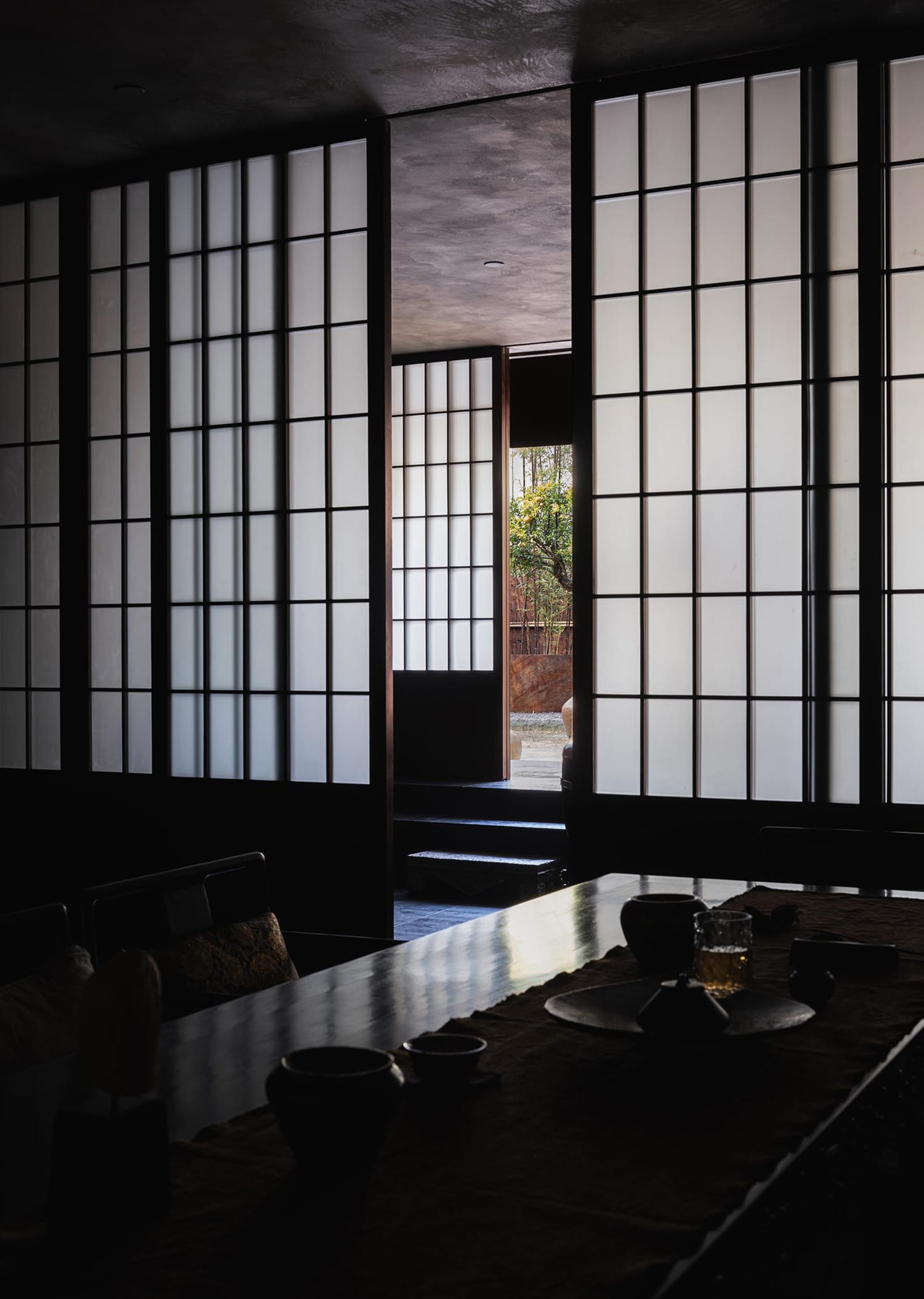 A classic and elegant dining area with a wooden table, chairs, and decorative vases, set against a black and white background
