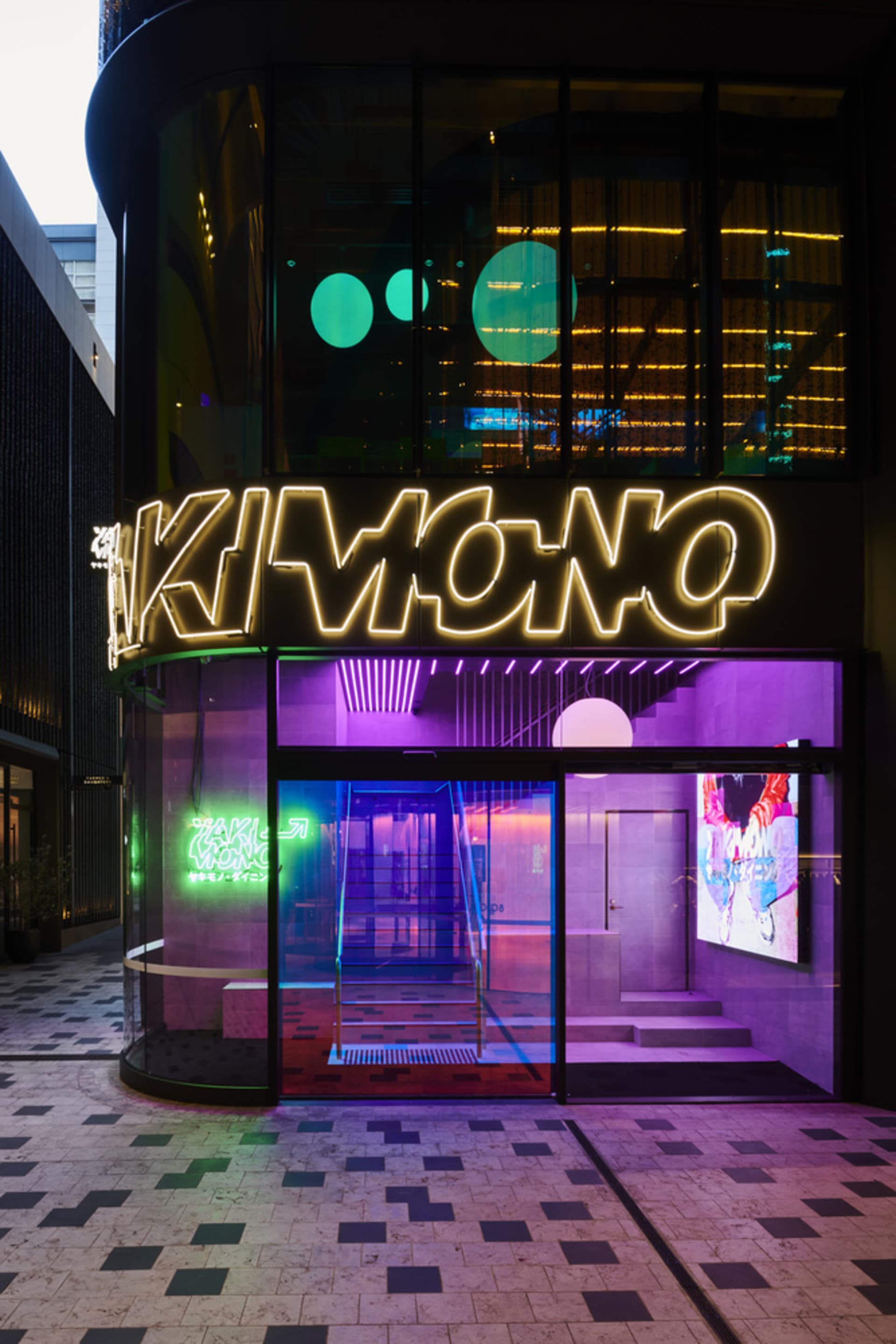 A modern interior space with neon-lit walls, a staircase, and two chairs, giving off a futuristic atmosphere