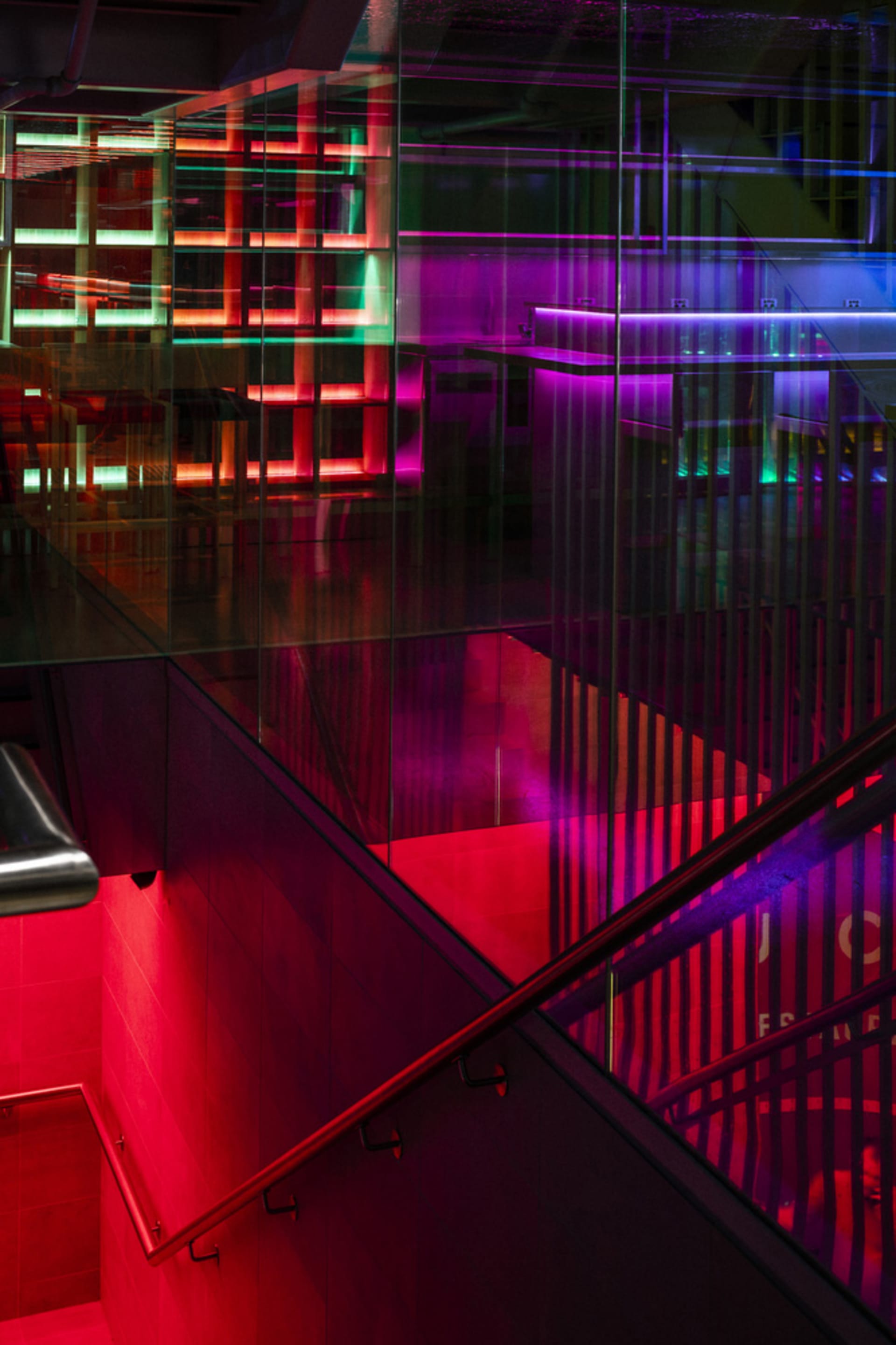 A modern glass staircase in a vibrant and visually appealing art gallery setting