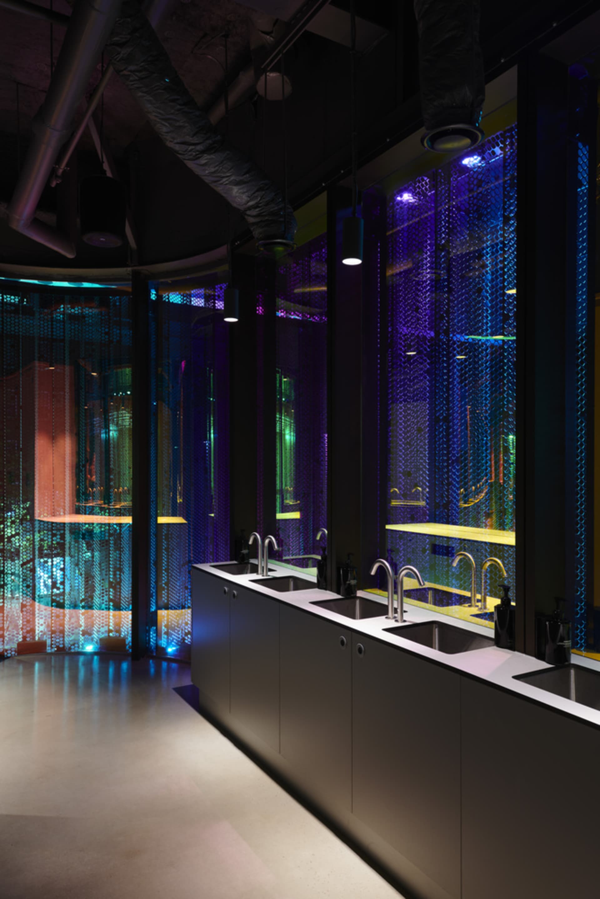 Modern bathroom with two sinks under a large window, black marble countertops, and a well-lit atmosphere