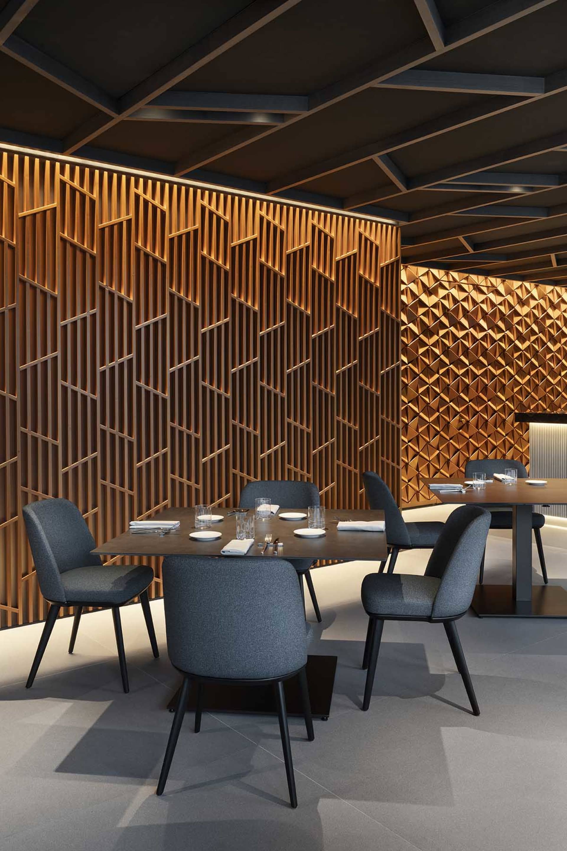Warm and inviting restaurant interior with wooden walls, tables, and chairs, adorned with white tablecloths