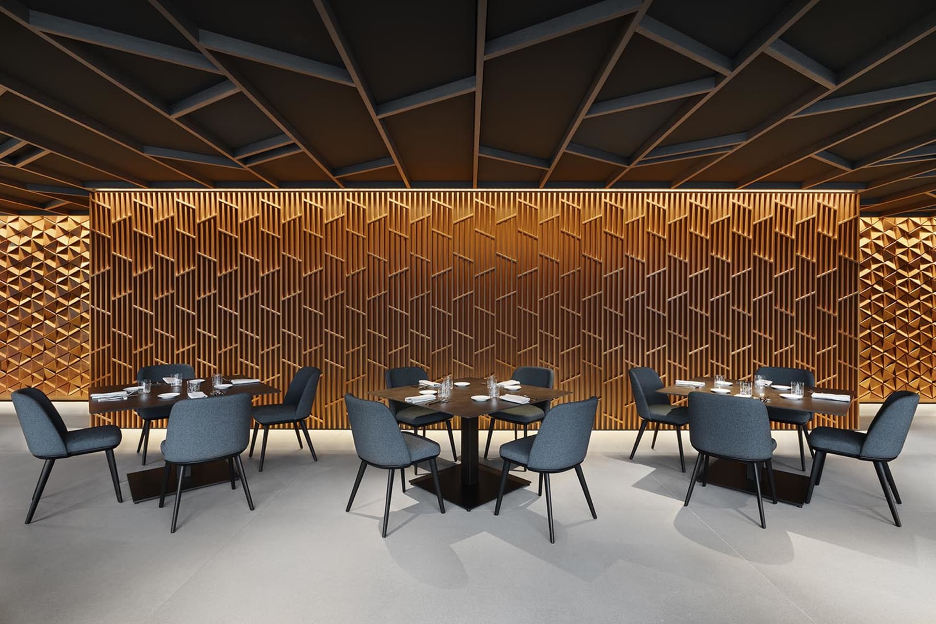 Empty restaurant with modern dining tables and chairs, wood elements, and a warm ambiance