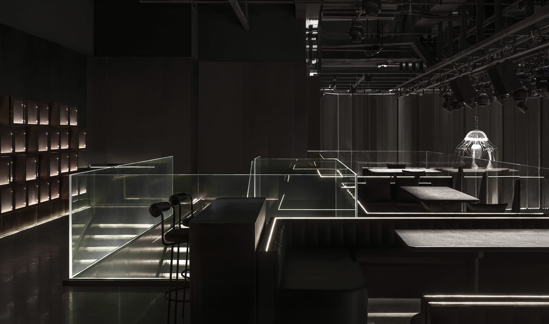 Dark and intimate dining space with modern design, clean lines, and minimalistic decorations