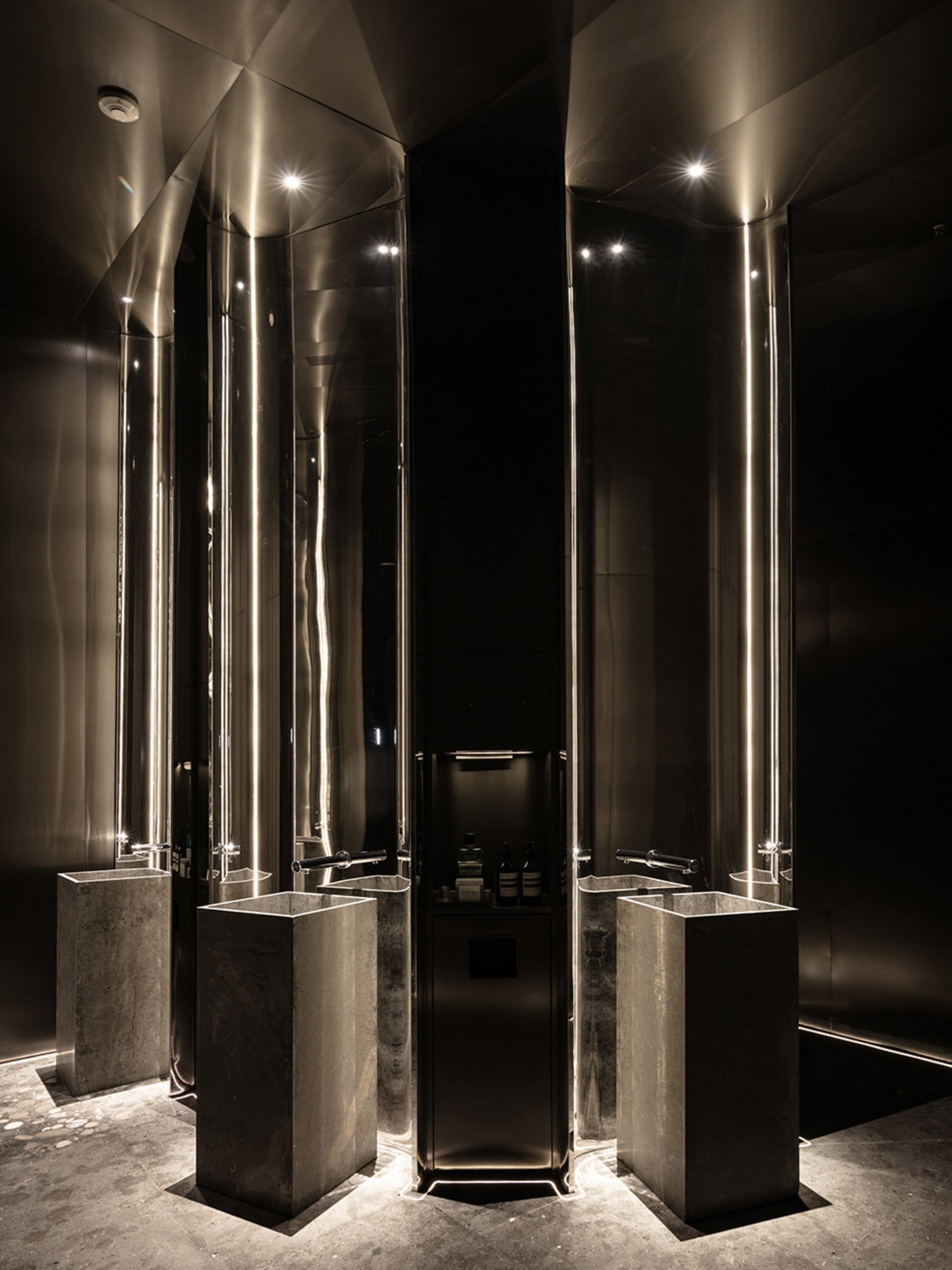 A bathroom with two marble sinks, bottles of soap and shampoo, and a well-equipped design