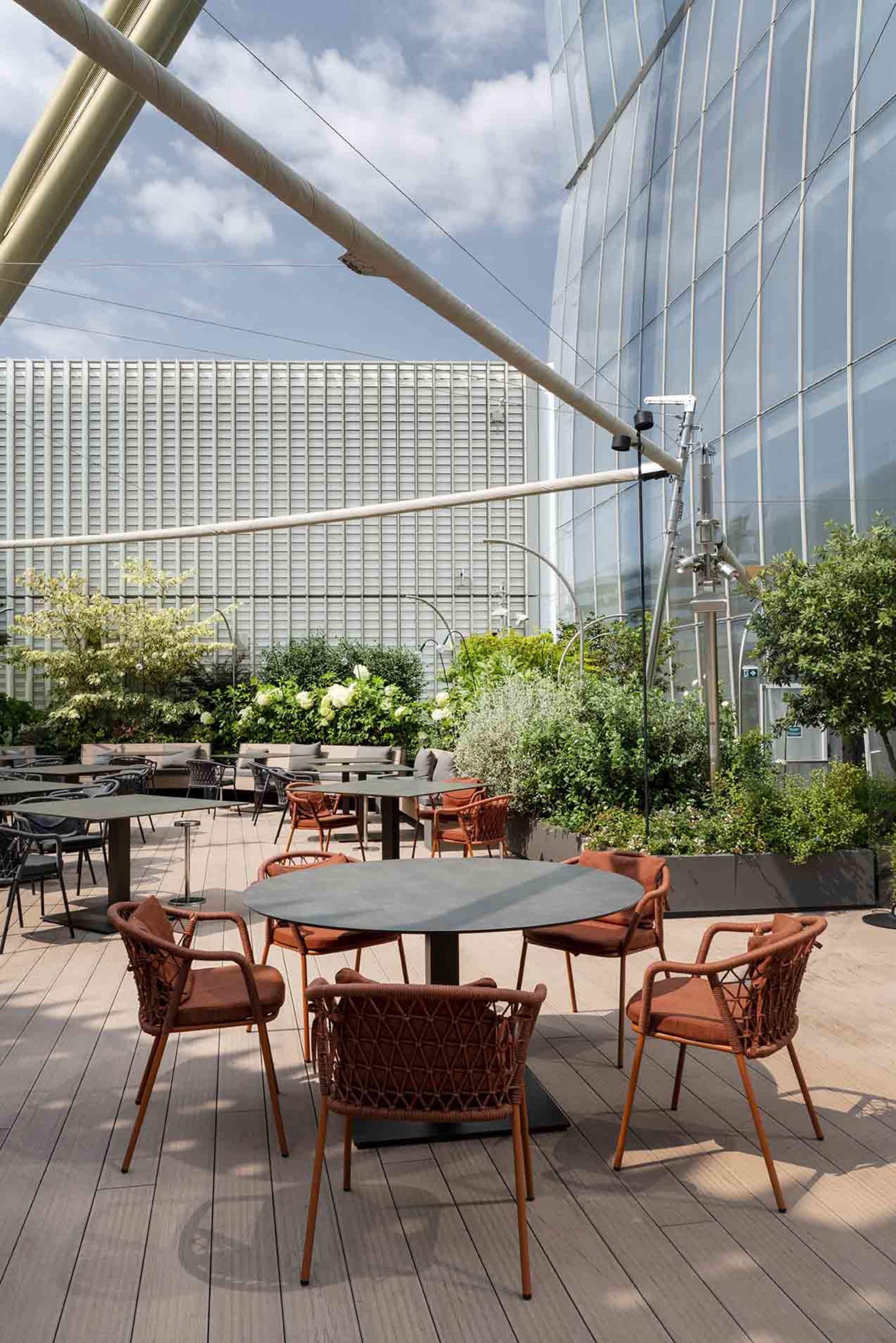 A modern dining space with multiple tables and chairs, designed for social gatherings and events, featuring a modern and inviting atmosphere