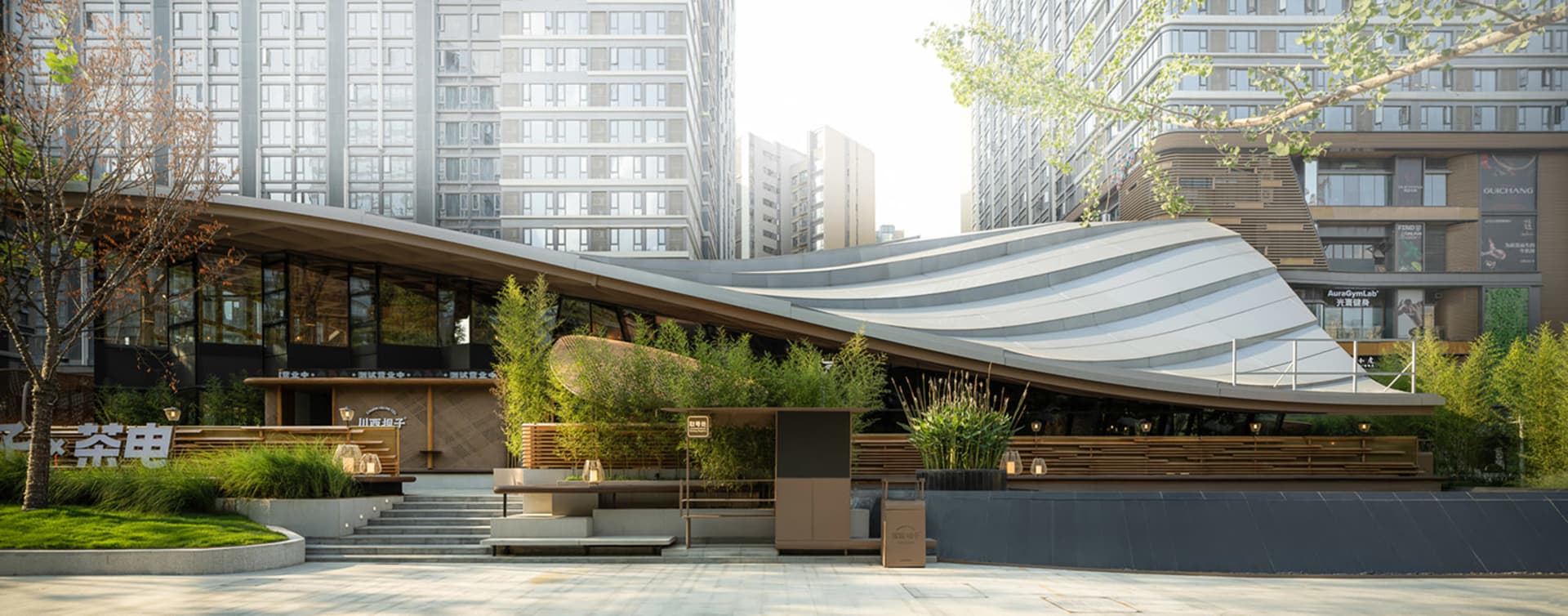 A city building with multiple levels and potted plants on the facade and ground level, adding a lively atmosphere