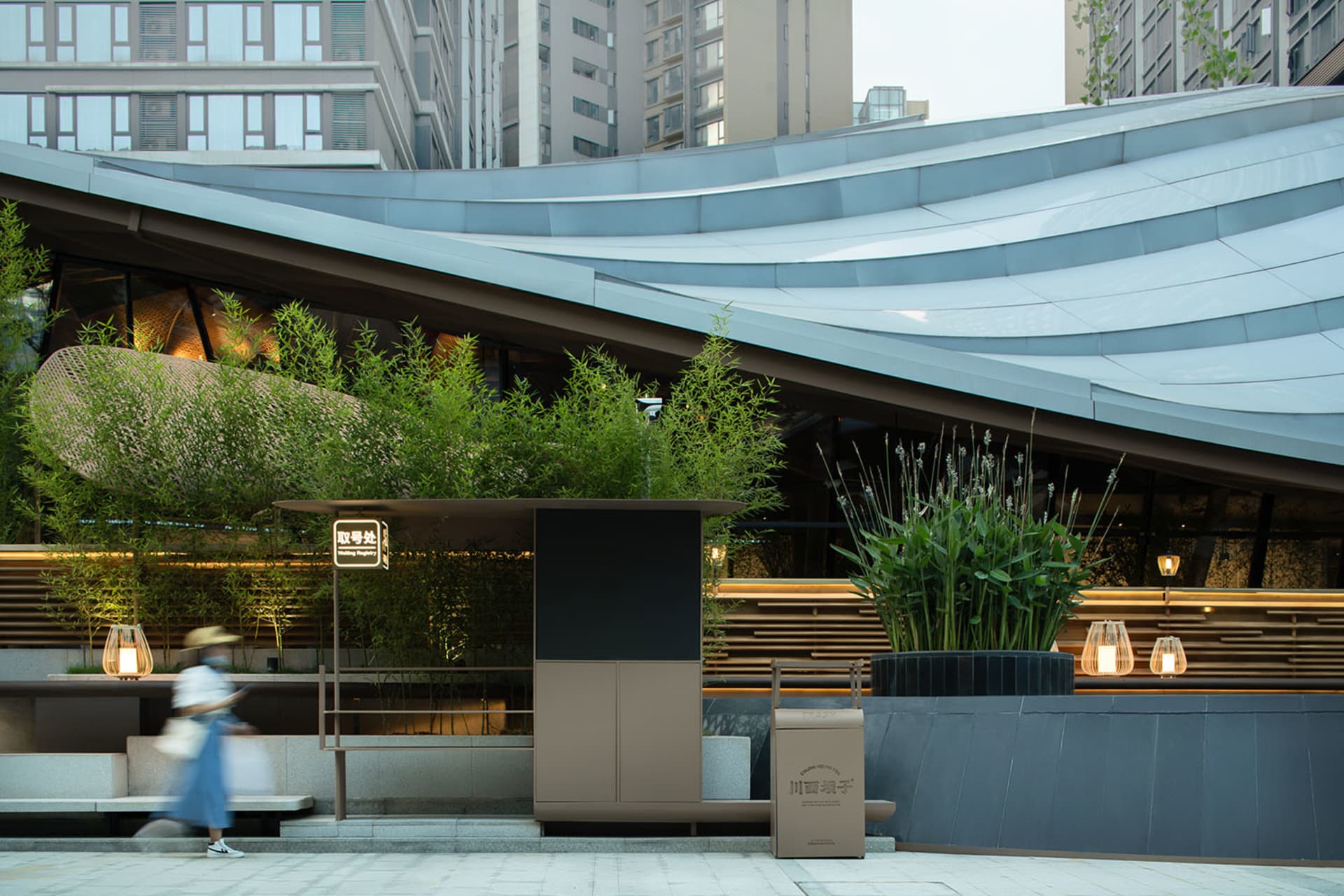 A serene urban setting with potted plants adding greenery to the environment, amidst a large building in the background