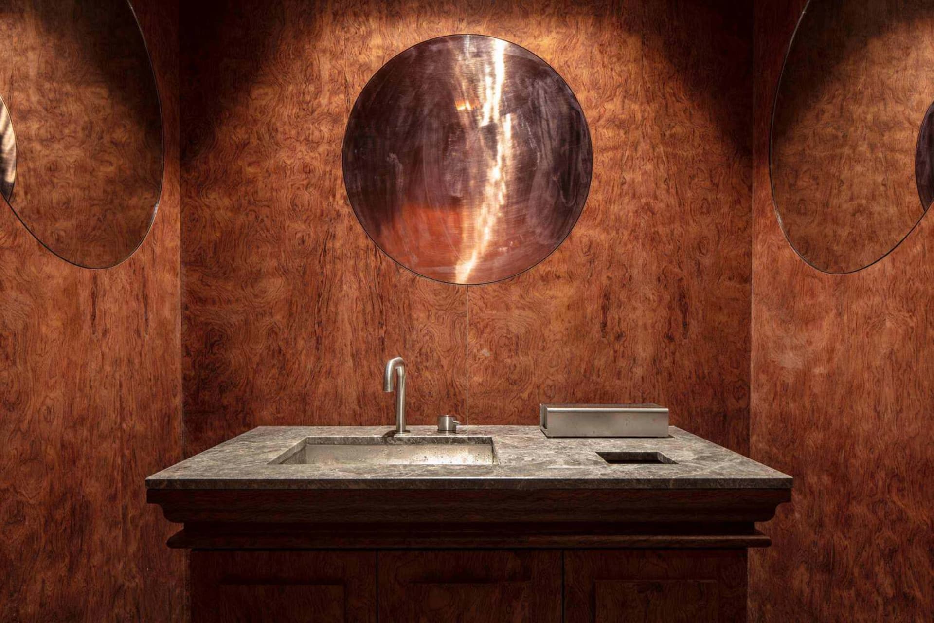 Bathroom with a sink, ornate mirror, and wooden countertop, featuring an elegant and well-designed atmosphere