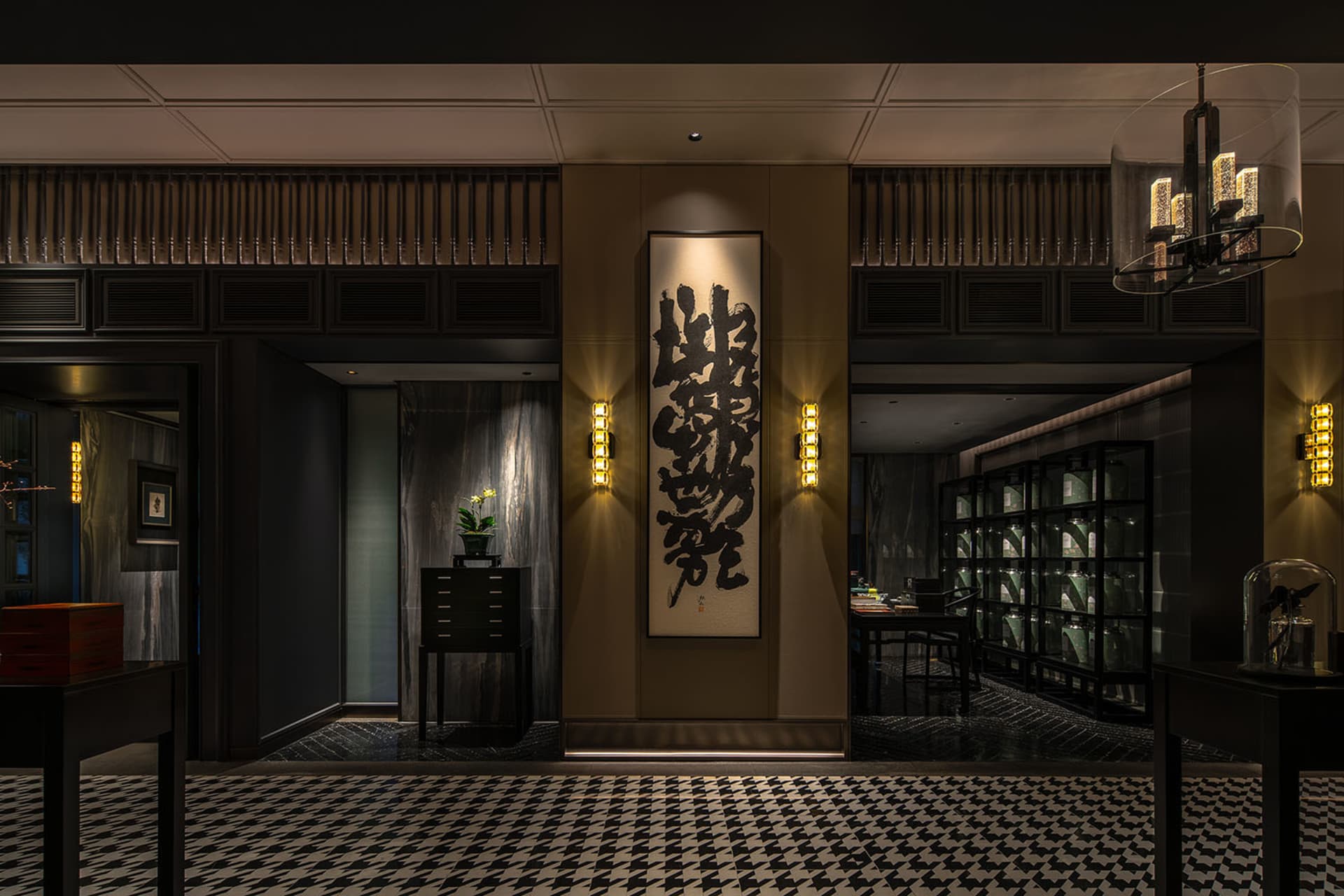 Asian restaurant interior with a large wall hanging of Chinese characters, checkered tile floor, potted plants, and wine glasses on display