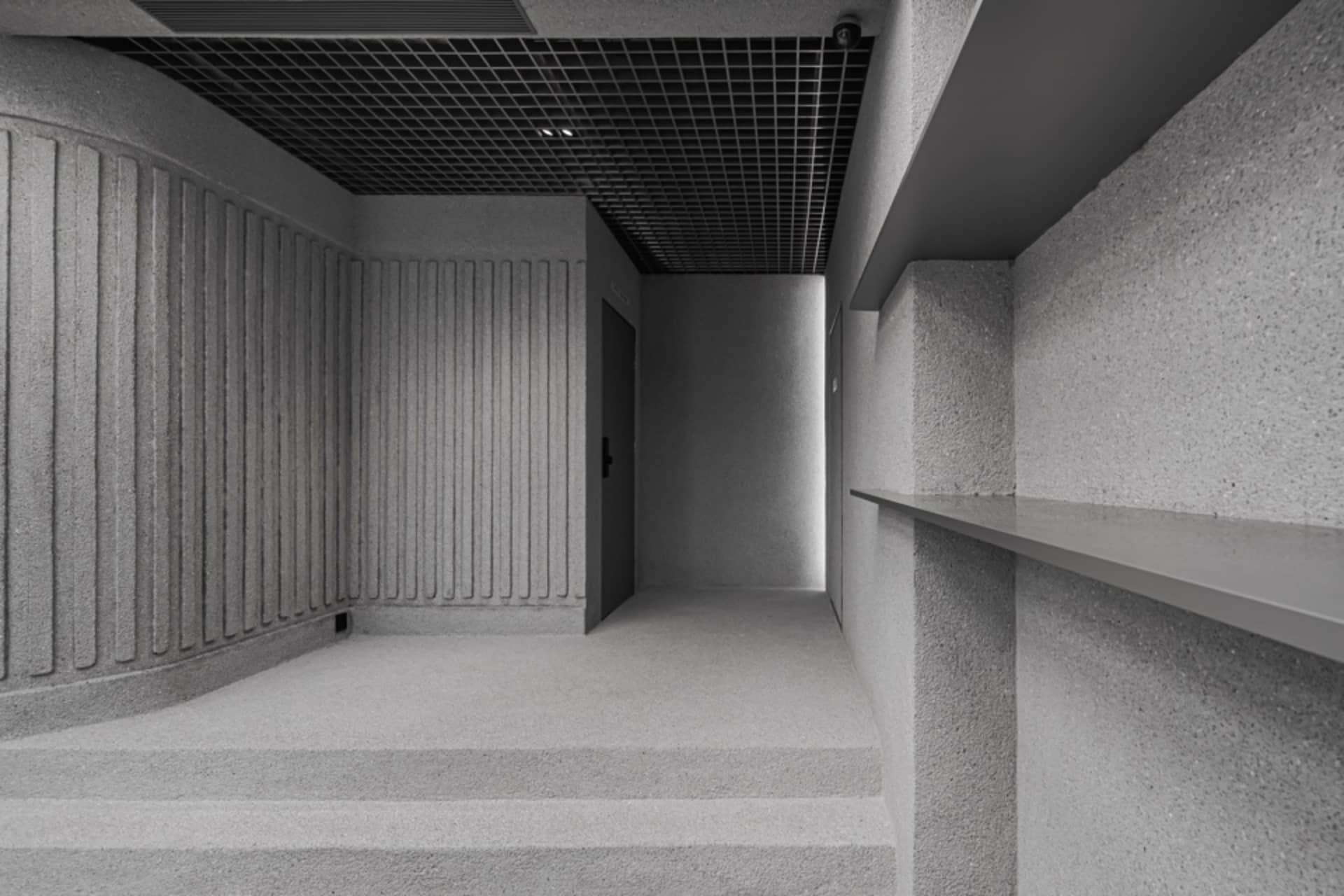 Empty industrial hallway with gray carpet and concrete walls, conveying a sense of quiet and simplicity