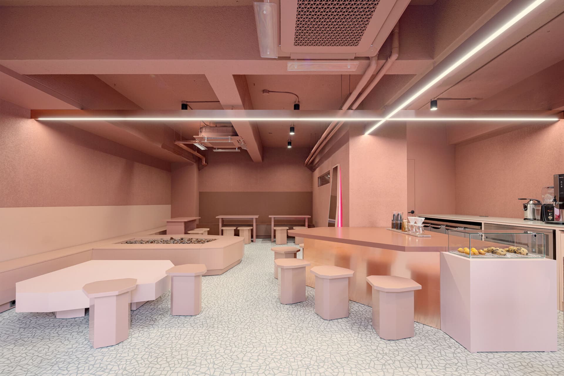 Inviting restaurant interior with pink walls, wooden tables, and comfortable seating areas