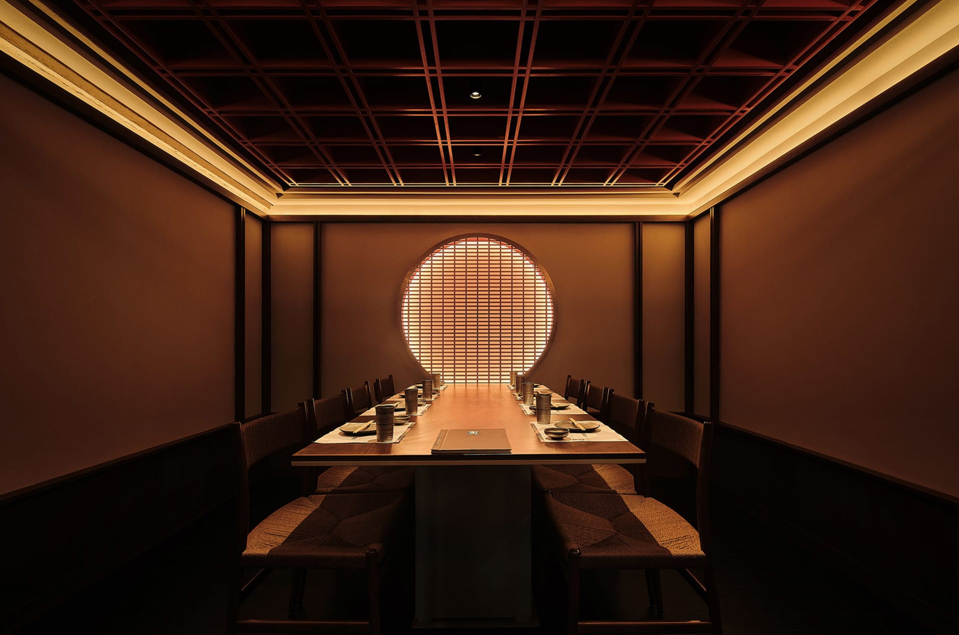 Elegant dining space with wooden walls and ceiling, featuring tables and chairs, and traditional Asian design elements