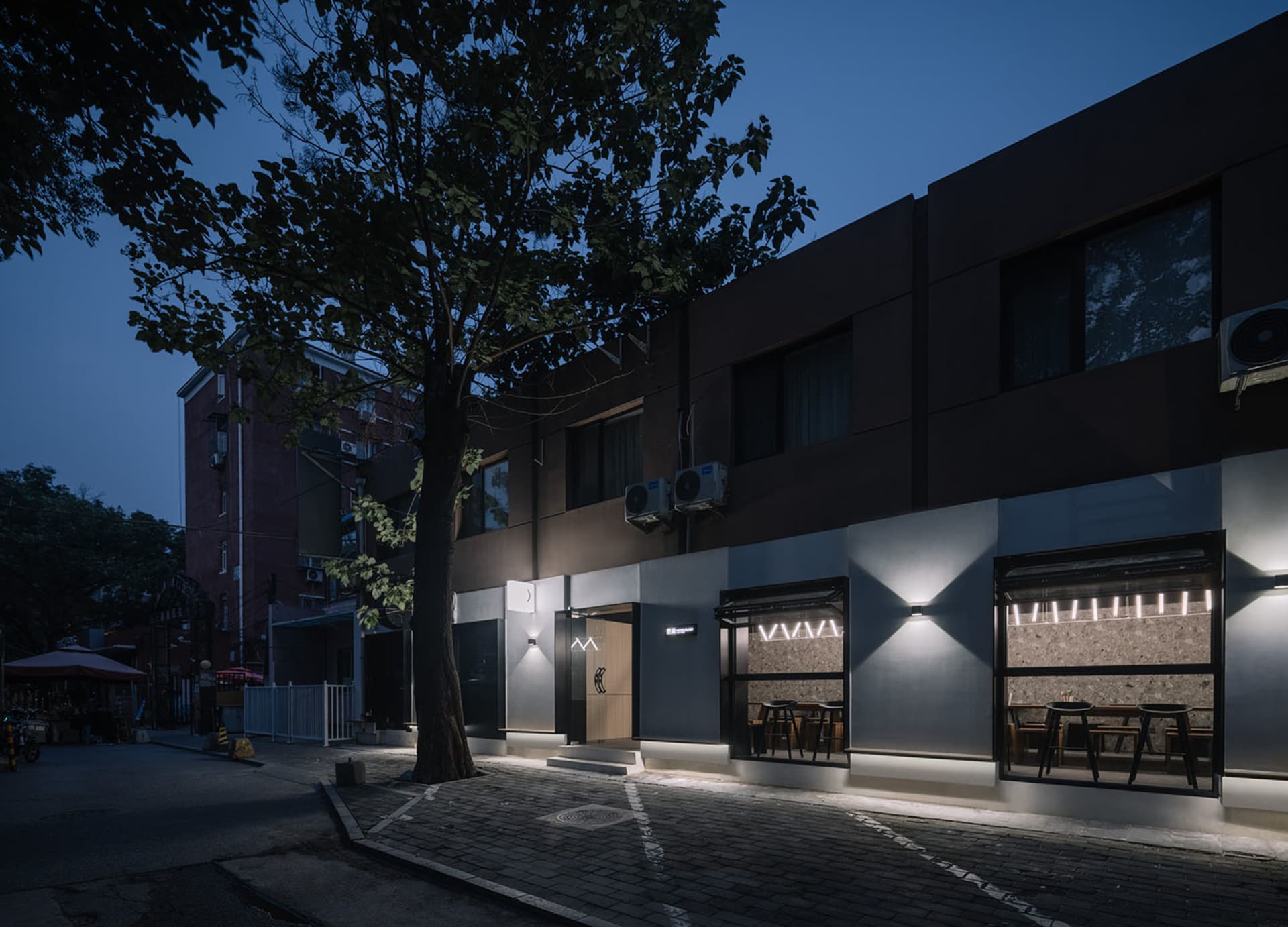 A restaurant at night with a brown exterior, dining tables, and chairs creating a cozy atmosphere for patrons