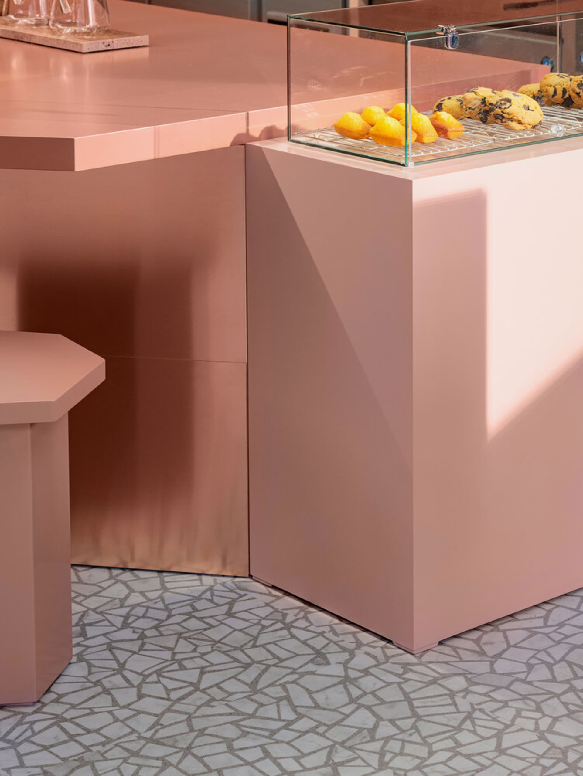 A warm and inviting kitchen scene with a pink countertop, displaying fruits and donuts, and a cozy atmosphere