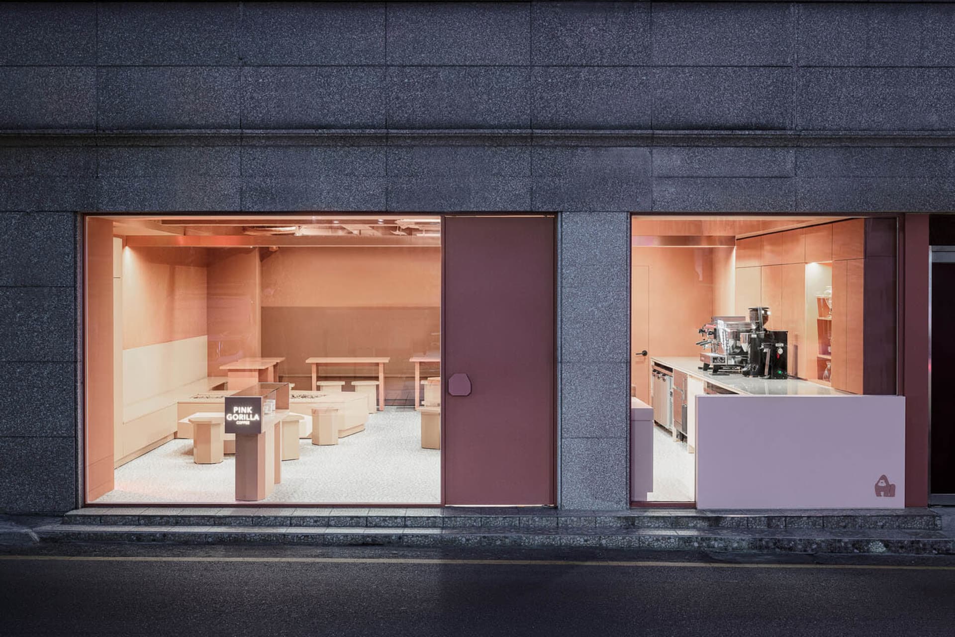 餐廳用餐區有多張桌椅、粉紅與灰色牆面，以及磁磚地板，營造溫暖親切的氛圍