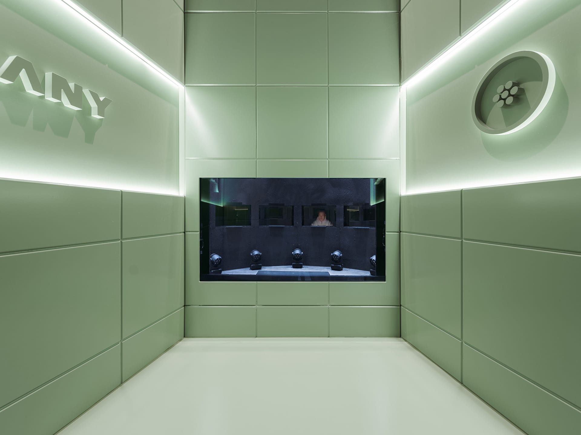 Empty room with green walls, a flat screen TV mounted on one wall, and a calm atmosphere