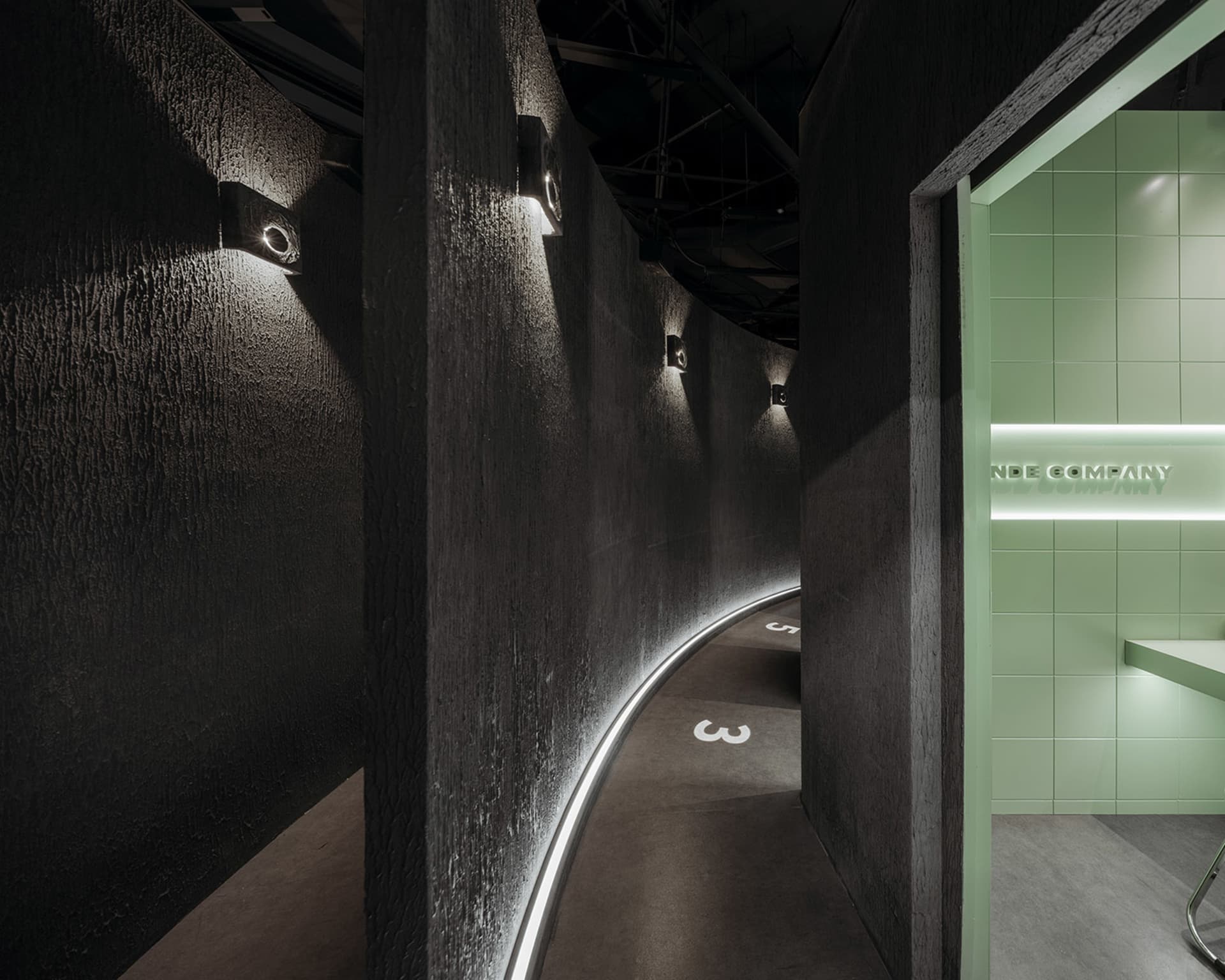 A dark and mysterious hallway with a curved design, black walls, and white numbers indicating distances or directions
